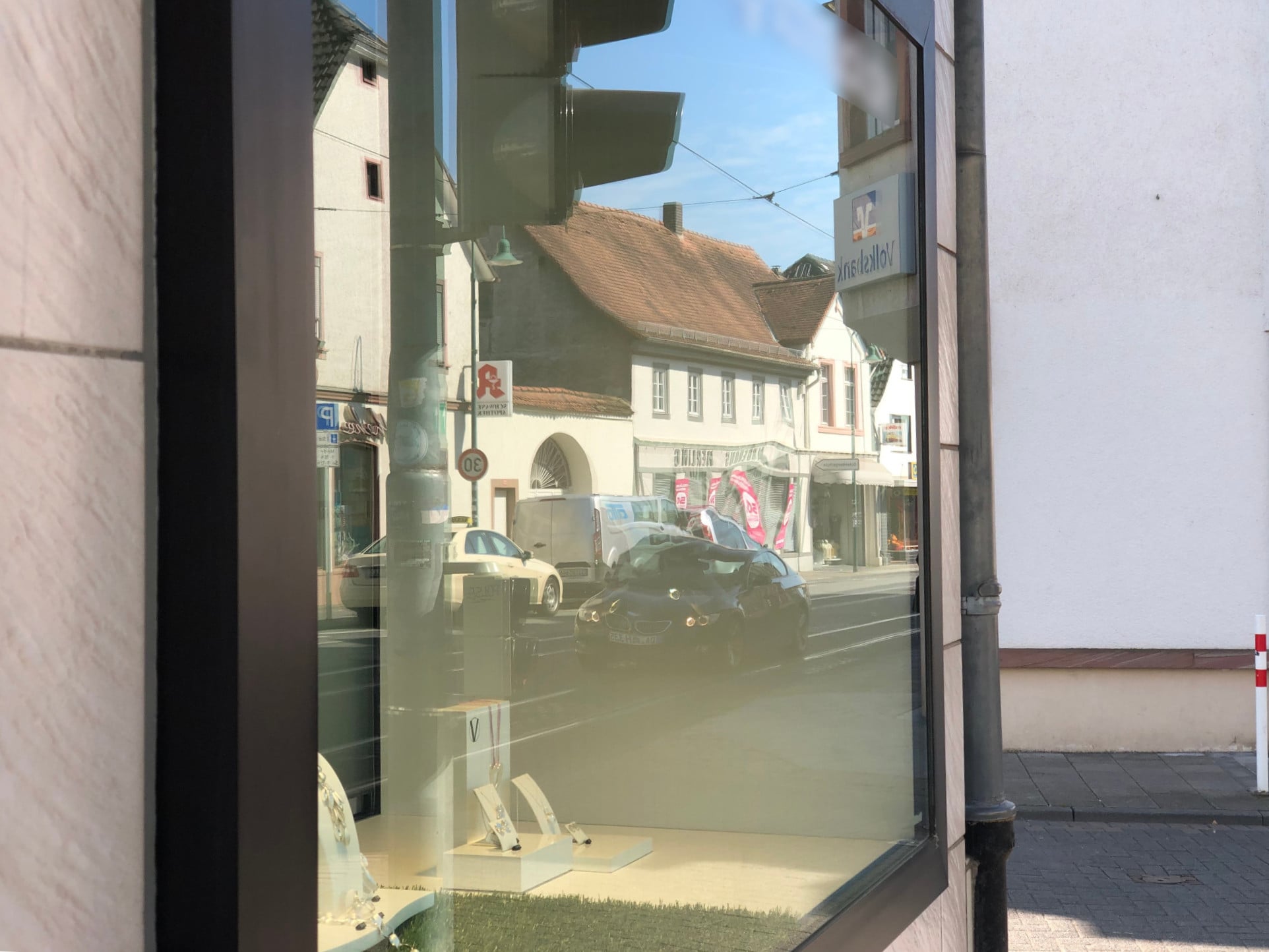 Linseneffekt auf einer Schauffensterverglasung (etwa in Bildmitte), hervorgerufen durch Anwendung des Polierverfahrens zur Entfernung einer Kratzspur