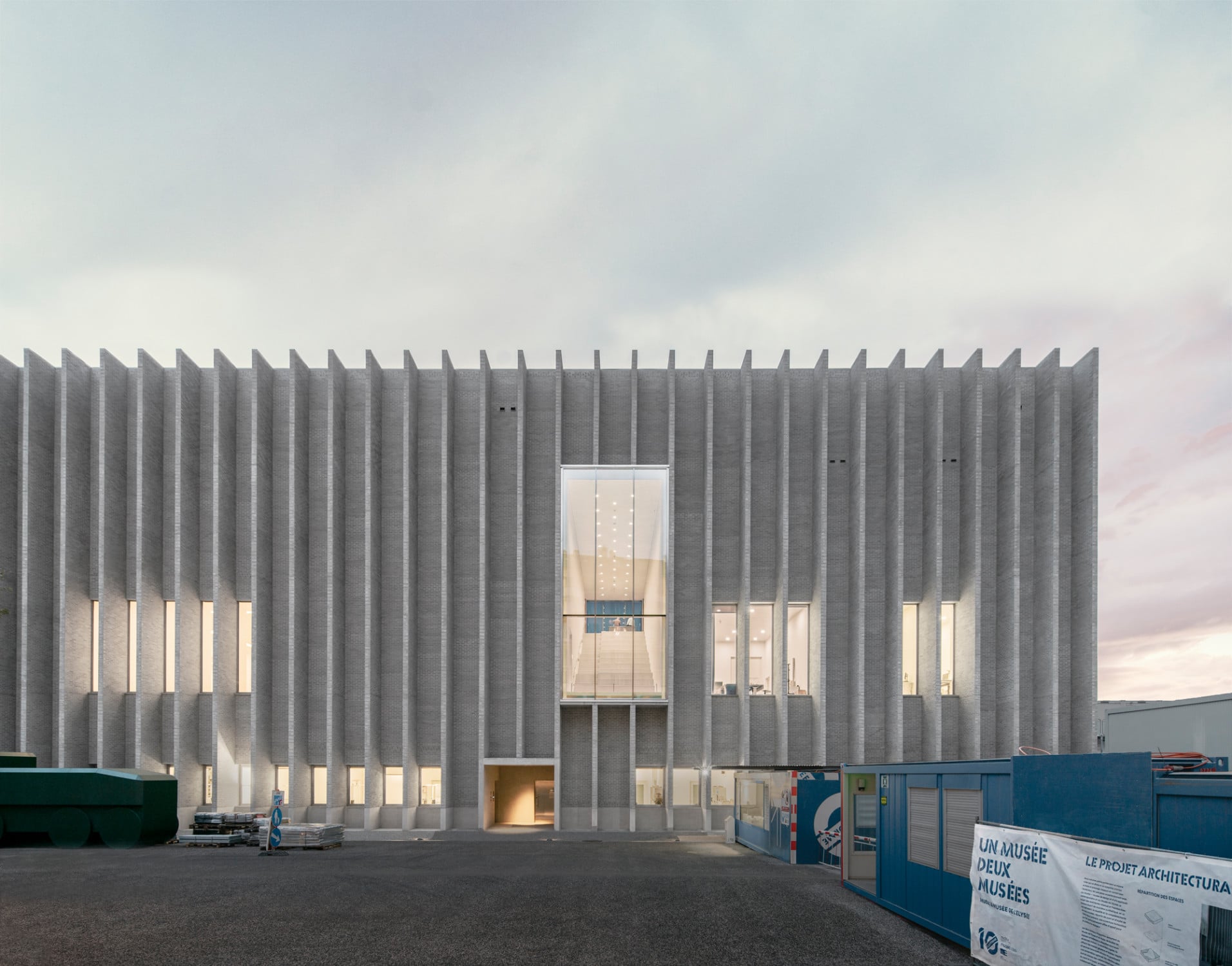 Steht man frontal zur Nordfassade, bemerkt man zwischen den vertikalen Lamellen, die zum Teil über mehrere Geschosse reichenden Fenster.