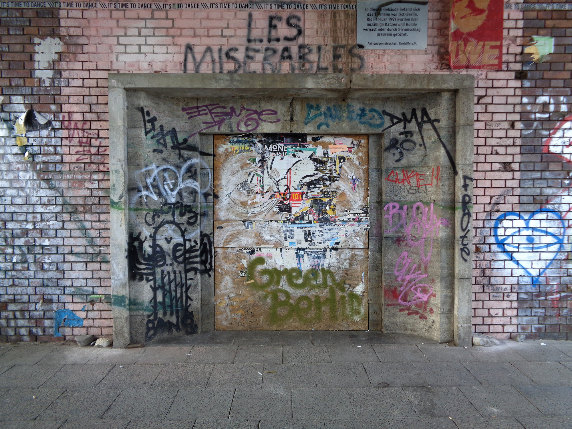 Farb- und Klebegraffitis an einer Sandstein-Laibung