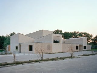 Das Kulturzentrum Pierre Blanche in Saint-Jean-de-Boiseau, das nach Entwürfen des Büros Raum entstand, liegt am südlichen Rand des Ortes, umgeben von Einfamilienhäusern, Sportanlagen und Feldern.