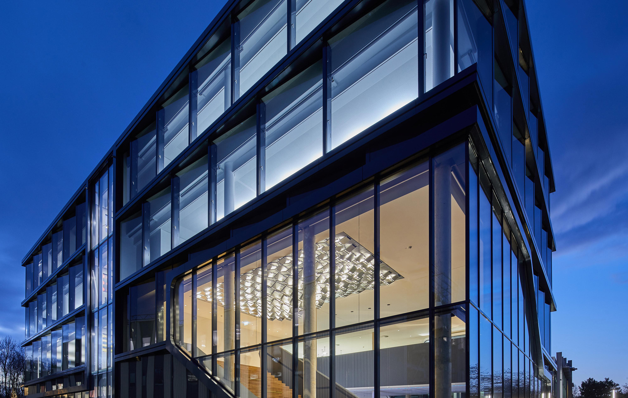 Das Firmengebäude mit klarer Form und vielen Glasflächen ist stark durch Licht, Lichtbrechung und Reflexionen geprägt, womit das Handwerk und Schaffen des Auftraggebers eindrücklich demonstriert wird.