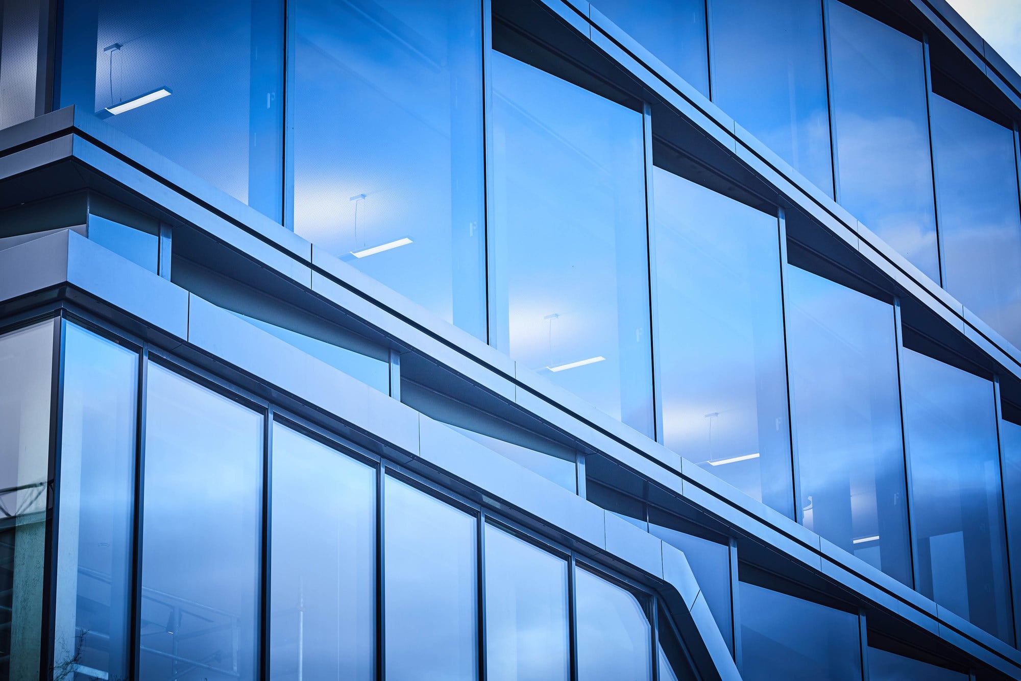 Der Bezug zu Licht lässt sich bereits an der Gebäudehülle ablesen: Die gestaffelte Glasfassade ist der Struktur von in Scheinwerfern verbauten Reflektoren nachempfunden, die die optische Verteilung der Lichtquelle optimieren.