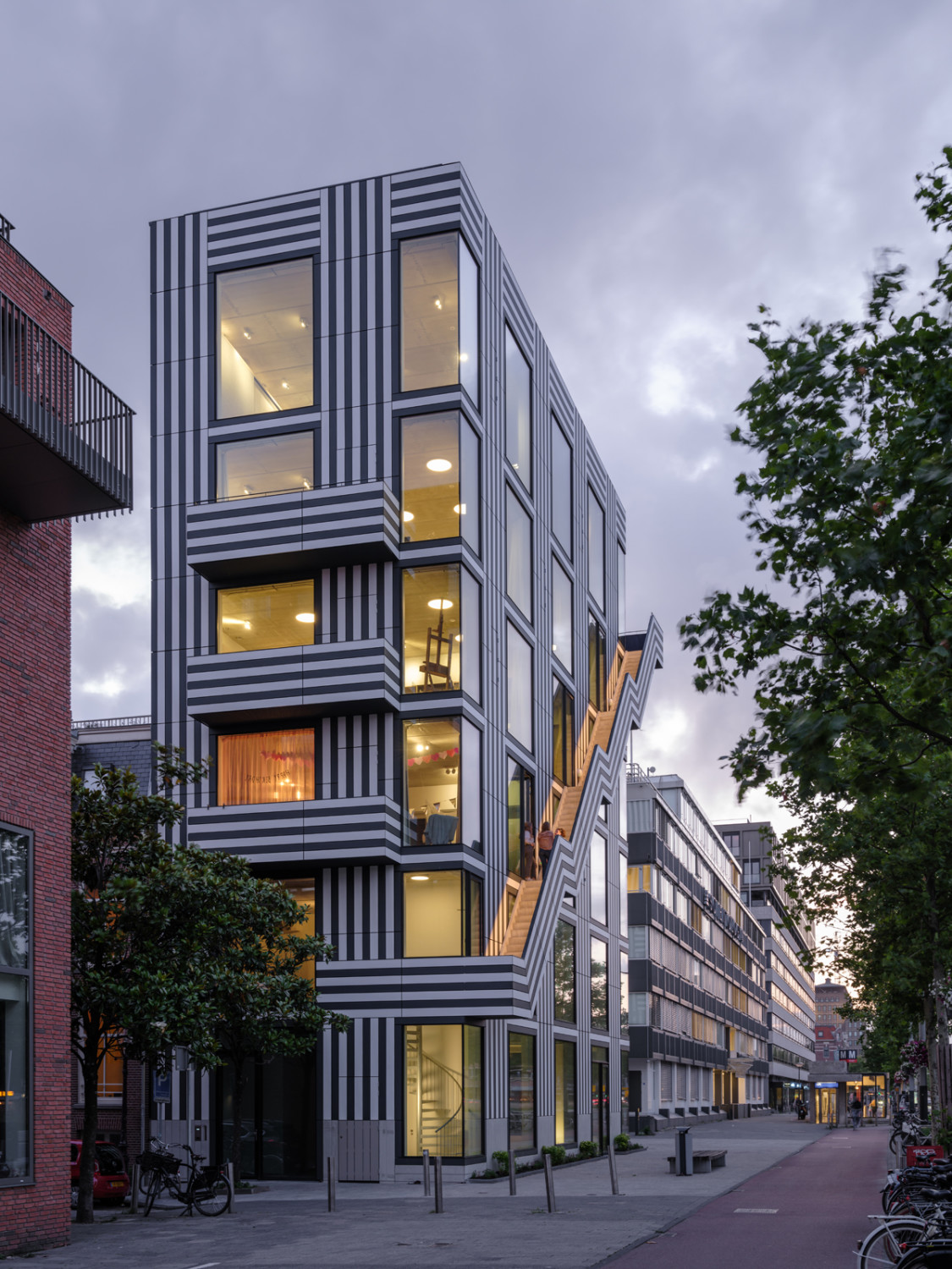 Raumhohe Glasflächen wechseln mit weißen und dunkelgrauen Streifen.