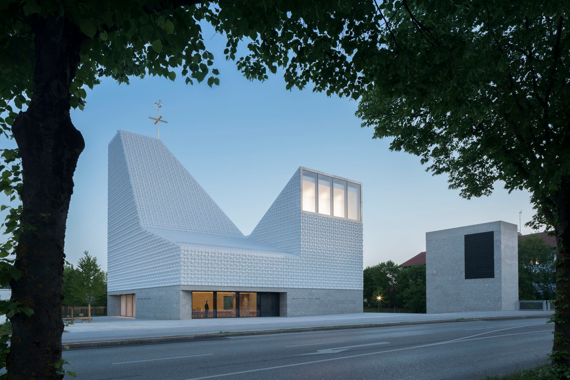 Mit seiner strahlend weißen, fein strukturierten Keramikfassade ist der skulpturale Bau ein echter Blickfang in der bayerischen Gemeinde Poing bei München.