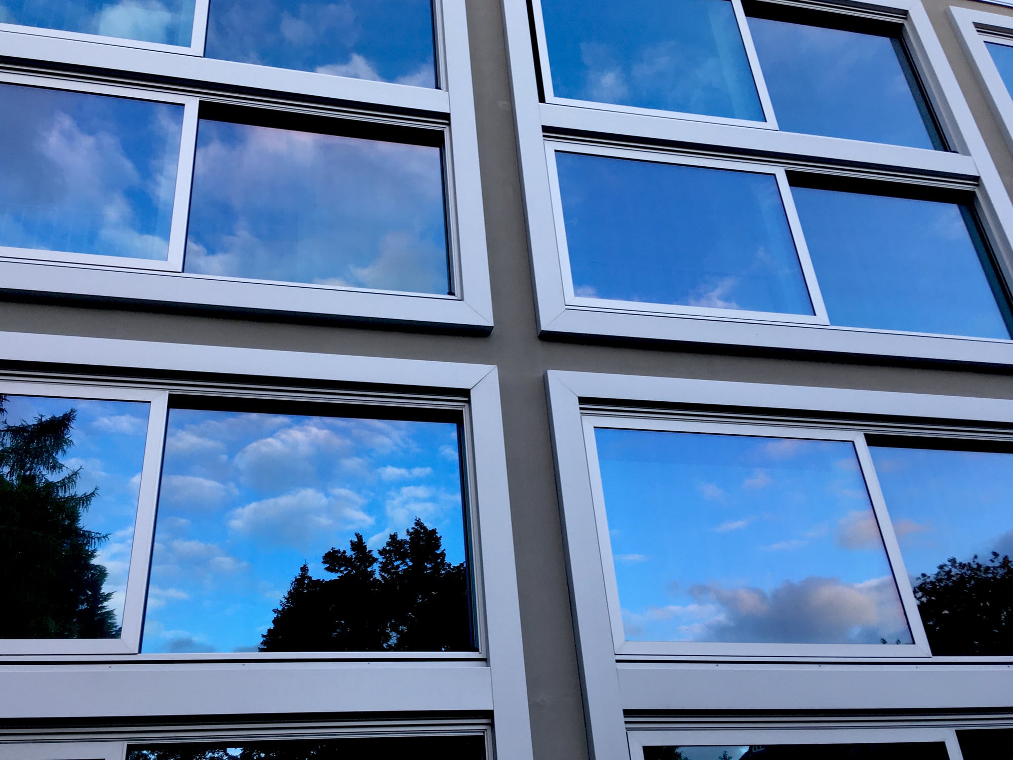 Ein orthogonales Raster aus Hebeschiebefenstern bildet Fensterkreuzen ähnliche geometrische Muster; Studentenwohnungen in Pankow, Architektur: Atelier Kempe und Thill, Rotterdam, 2020