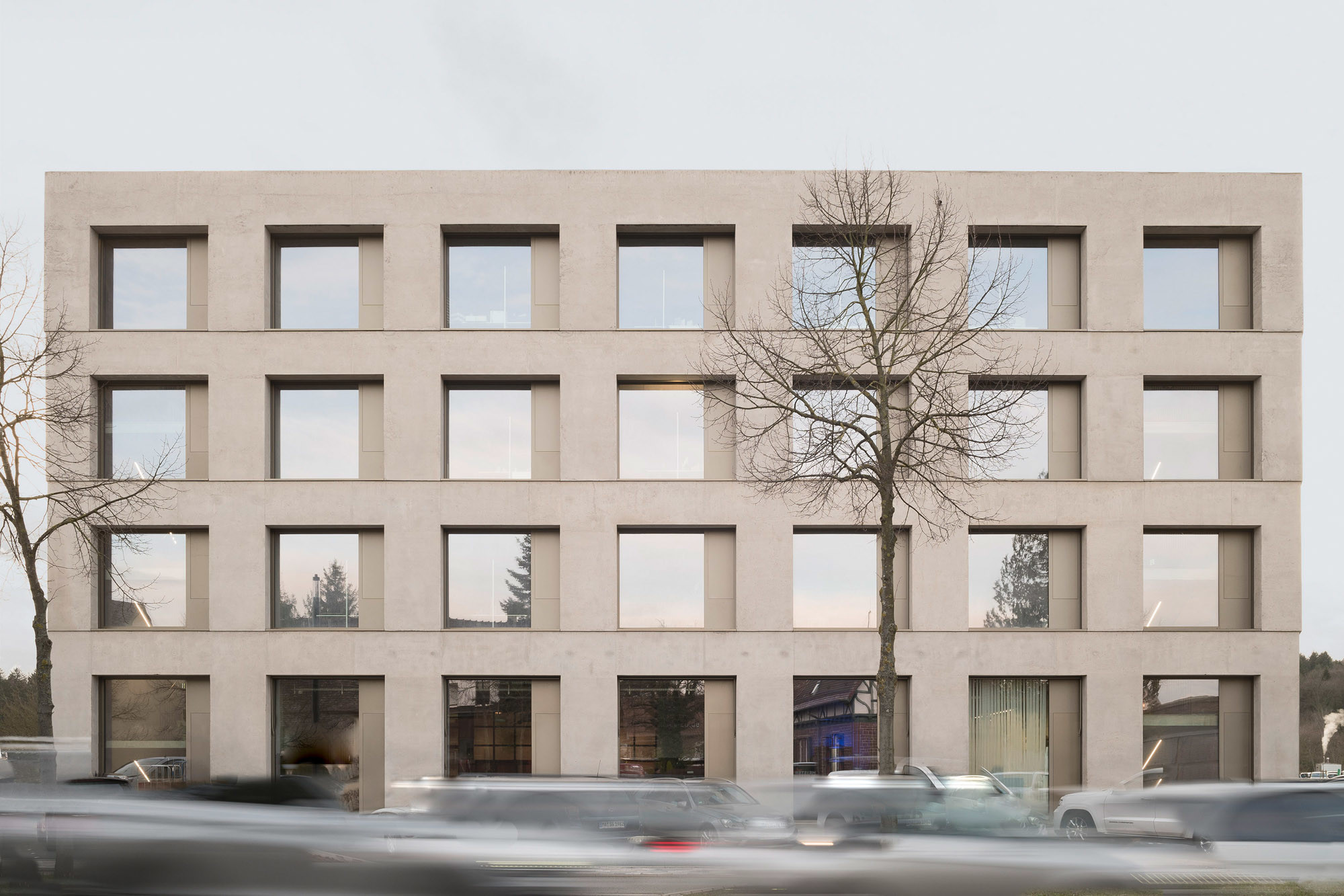 Die Fassade besteht aus hellgrauem Dämmbeton und farblich abgestimmten Aluminium-Fensterelementen.