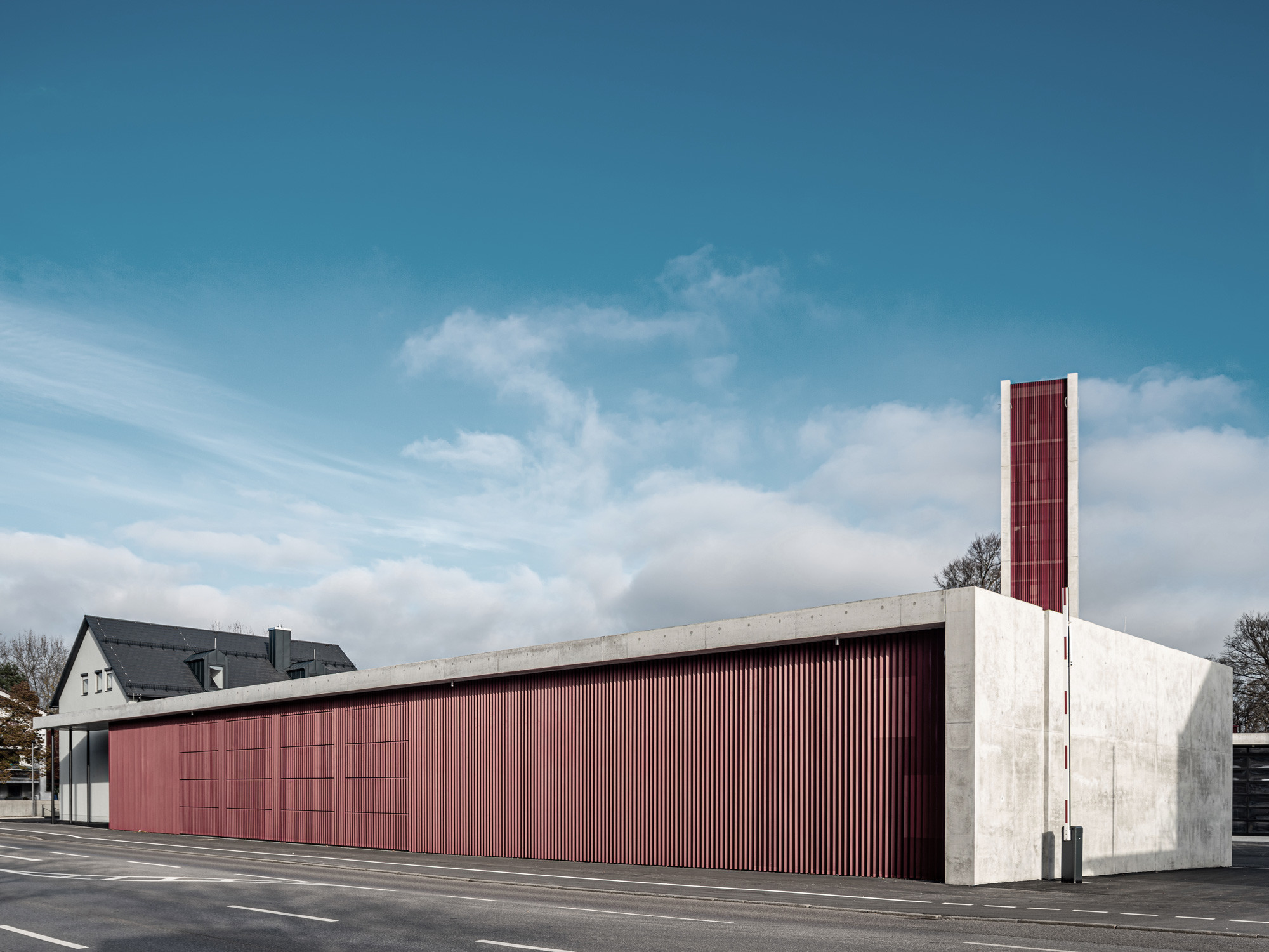 Die Materialien: Stahlbeton und eine profillierte Metallbekleidung in Dunkelrot.