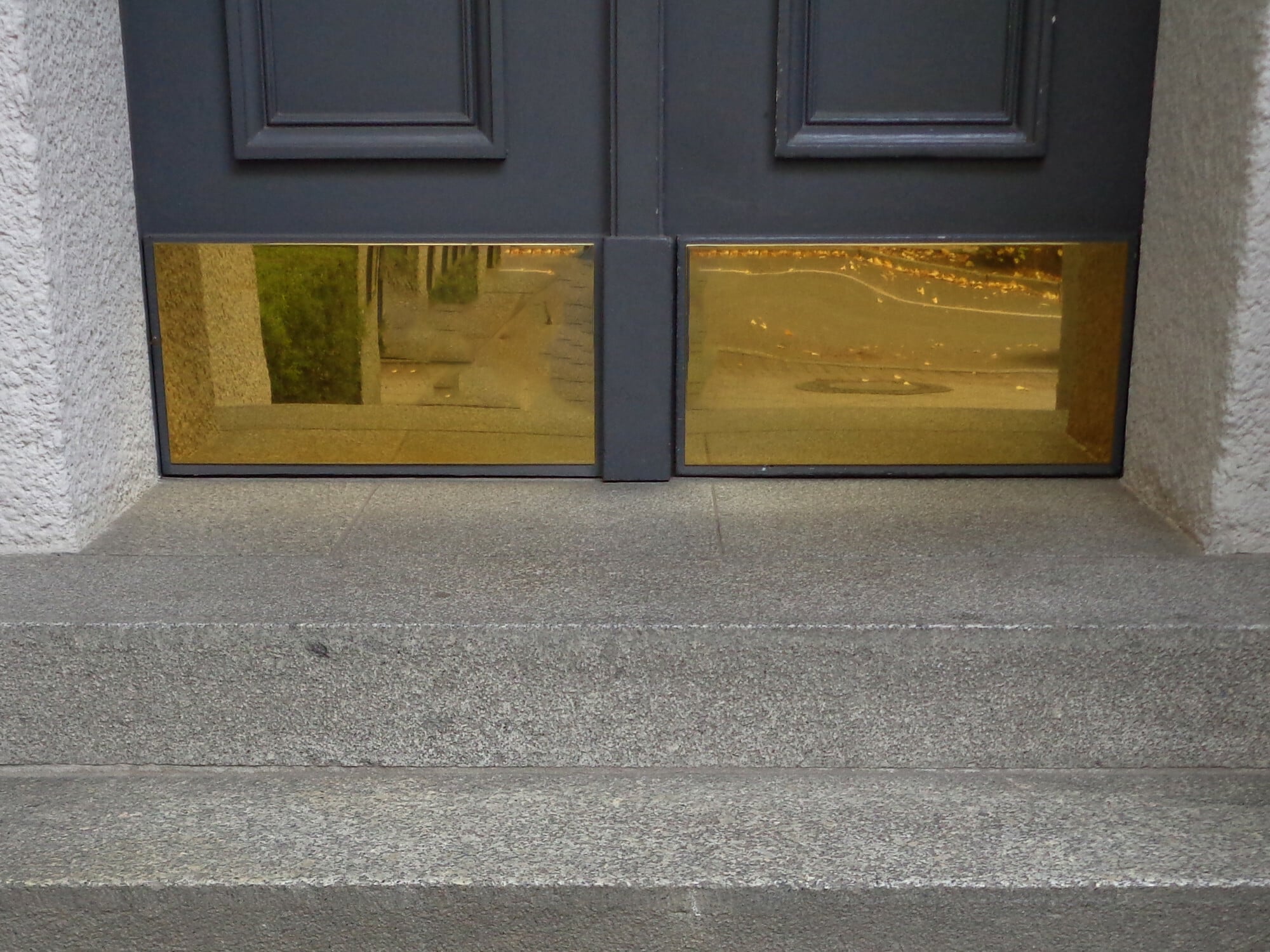 Der untere äußere Bereich von Hauseingangstüren ist oftmals besonders stark beansprucht. Sockelbleche schützen vor Beschädigungen (im Bild: hochglänzend poliertes Messing).