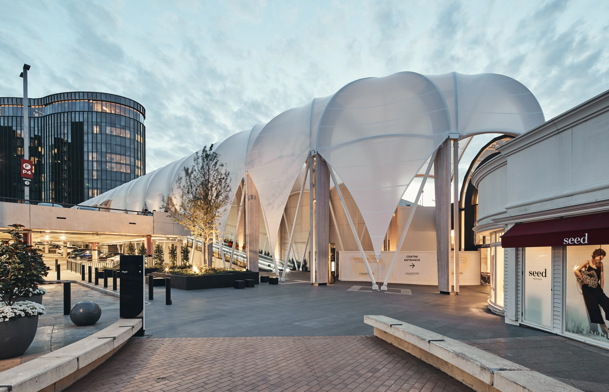 Wie aneinandergereihte Pavillons erscheint der Bau aus Brettschichtholzbögen und aussteifenden Stahlhohlprofilen mit einem halbtransparenten PTFE-Baldachin.