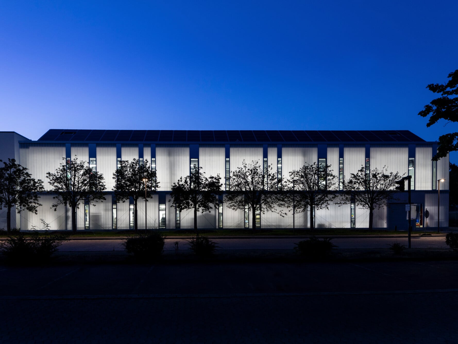 Bei eingeschalteter Beleuchtung strahlt die revitalisierte Produktionsstätte nachts transluzent. Der Entwurf stammt aus der Feder der Architekten Bünemann & Collegen. 
