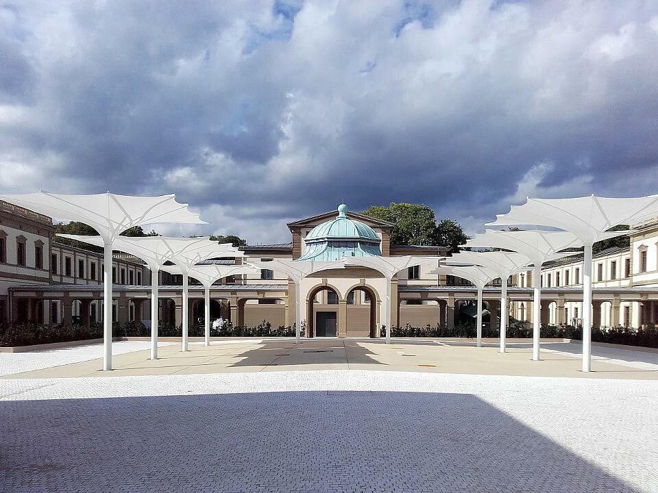 Synchron zur Symmetrie der historischen Architektur hat MDT den Platz im Hof des Luitpoldbads in Bad Kissingen mit maßgeschneiderten Sonnenschirmen ausgestattet.