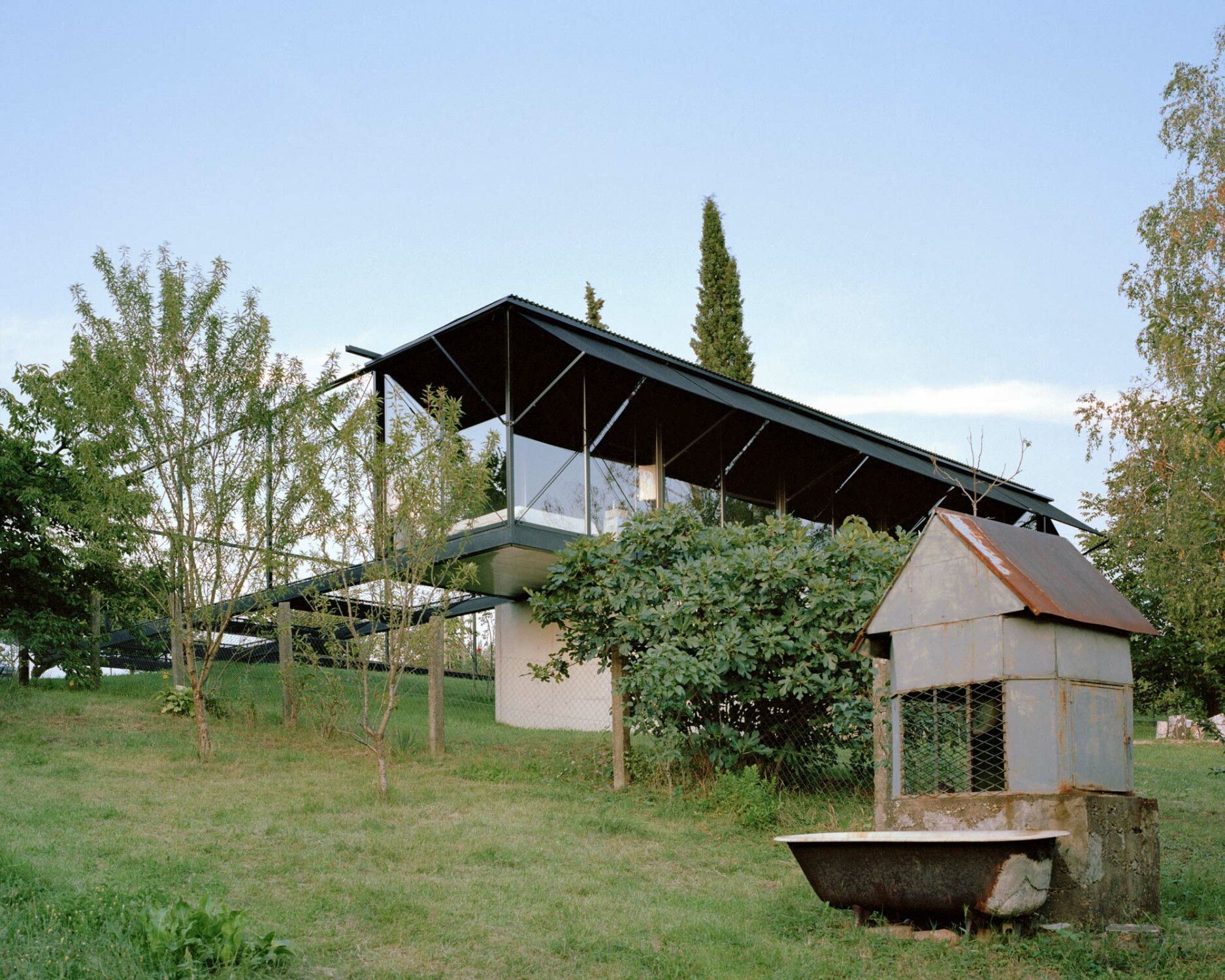 Der Bungalow aus Stahl, Glas und Beton ragt über das abschüssige Grundstück.