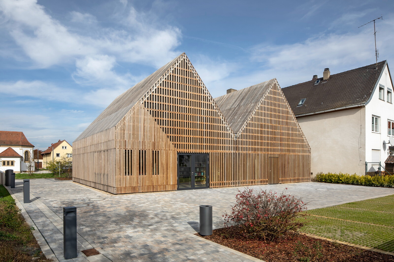 Buchstäblich stülpt sich der Neubau über das historische, deutlich kleinere Stallgebäude – das war der Ausgangspunkt des Haus-im-Haus-Themas, das sich wie ein roter Faden durch den gesamten Entwurf zieht.