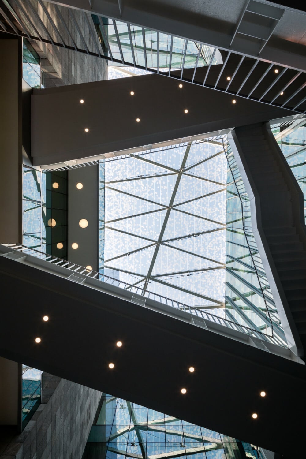 Die geradlinige Architektur, in der Stein- und Glasflächen dominieren, wird im Innenhof durch eine Reihe von Brücken und Treppen aufgelockert.