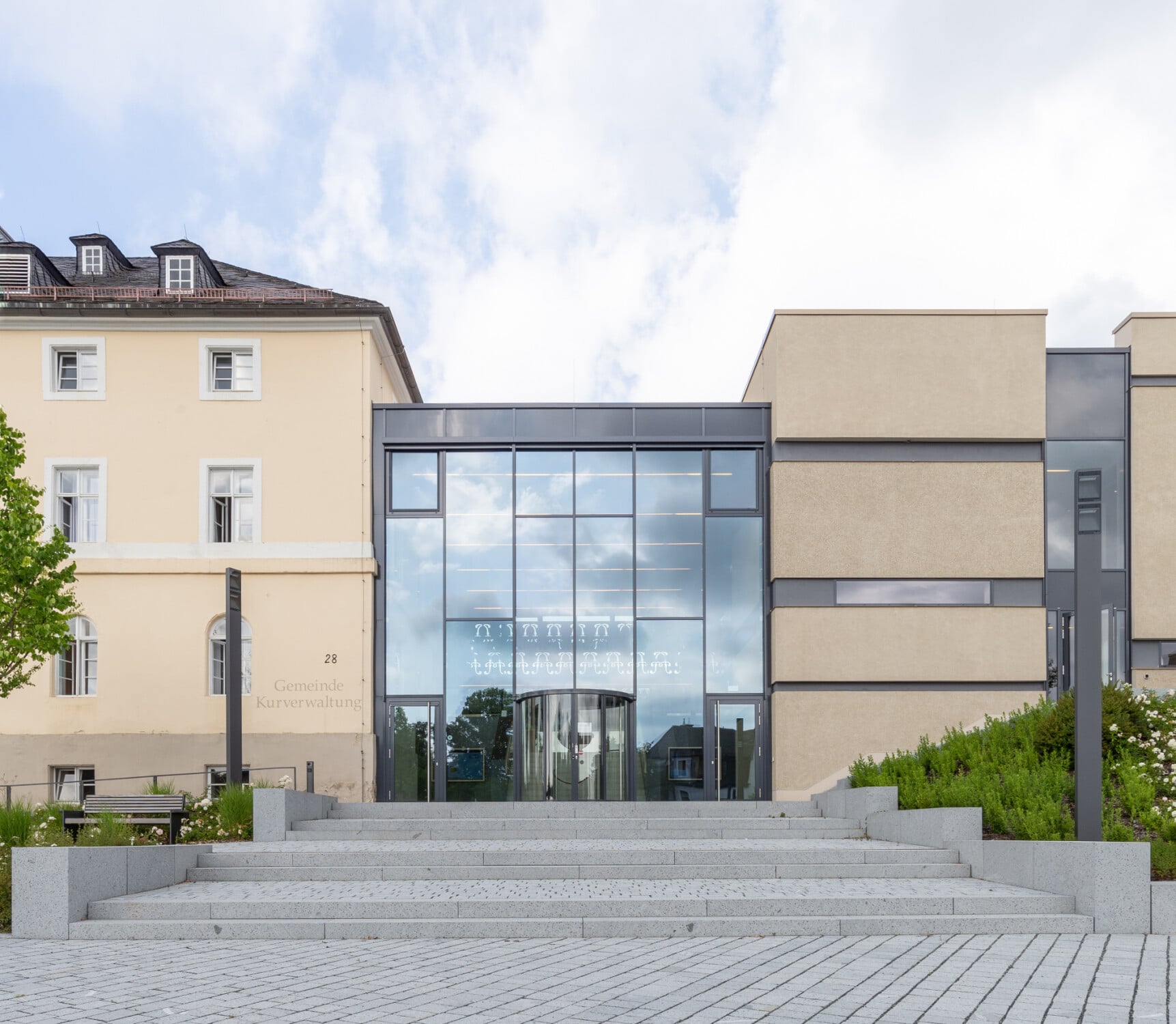 Brückner und Brückner platzierten den L-förmigen Baukörper des neuen Kurhauses neben das alte Kurhaus und verbanden beide über eine breite, gläserne Fuge, in der sich der Empfangsbereich befindet.