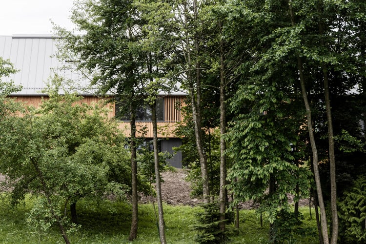 Mit dem Kontext korrespondierend, trägt der Bau auch der Topografie des Grundstücks am Bachlauf Rechnung.