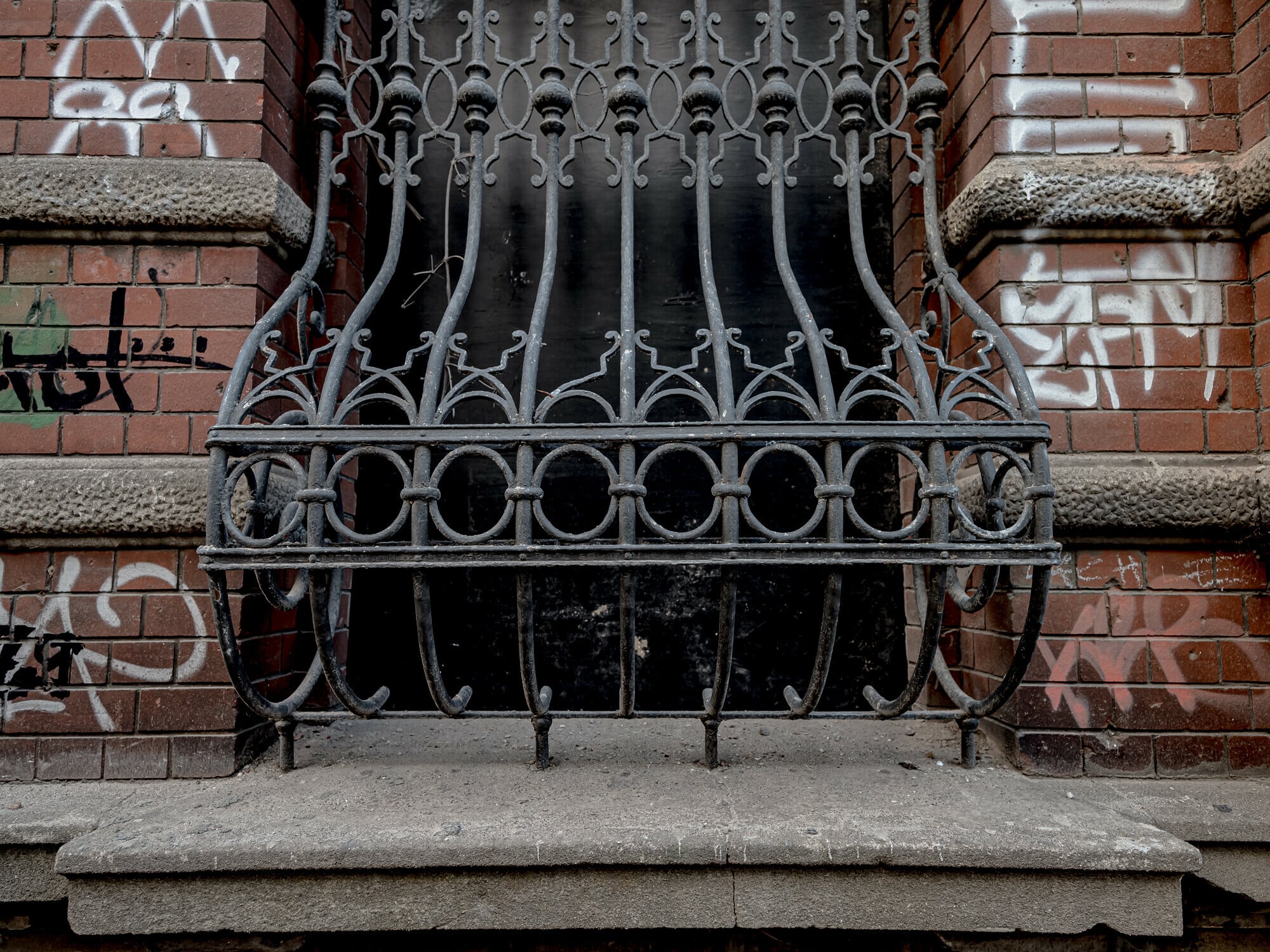 Ein historischer Fensterkorb in einer großen Fensteröffnung an einer unsanierten Fassade