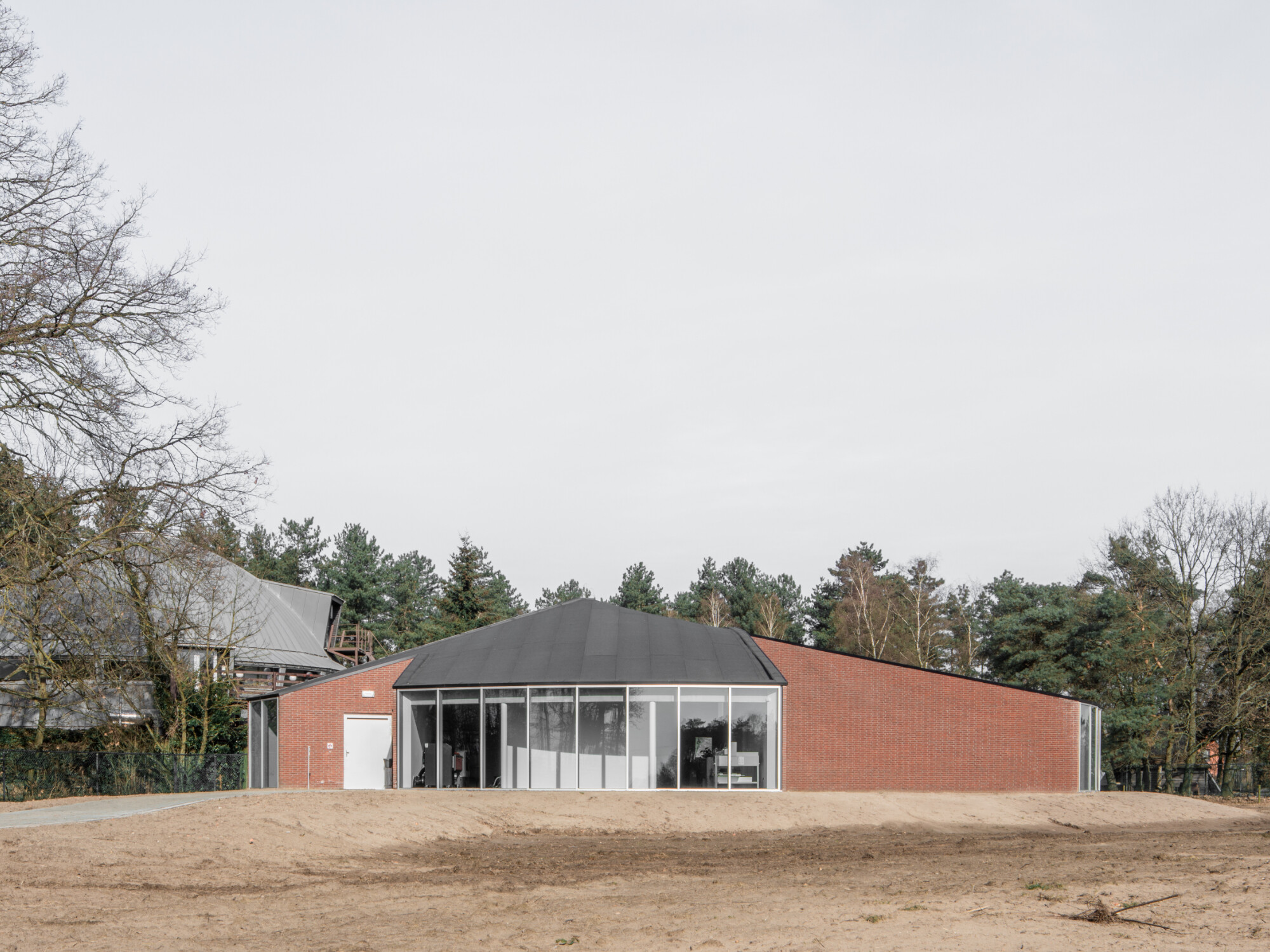 Die geometrische Grundform des Anbaus ist ein Kreis, der sich räumlich als Zylinder und schiefer Kreiskegel abbildet. Aus dieser Grundstruktur wurden einzelne Teile, Tortenstücken ähnlich, herausgeschnitten. 