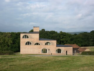 Inmitten der sanften Hügellandschaft des südenglischen Nationalparks South Downs ließ der britische Architekt Adam Richards ein Wohngebäude für sich und seine Familie errichten. 