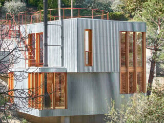 Arquitectura-G aus Barcelona schufen ein leicht und verspielt wirkendes Gebäude am Hang.