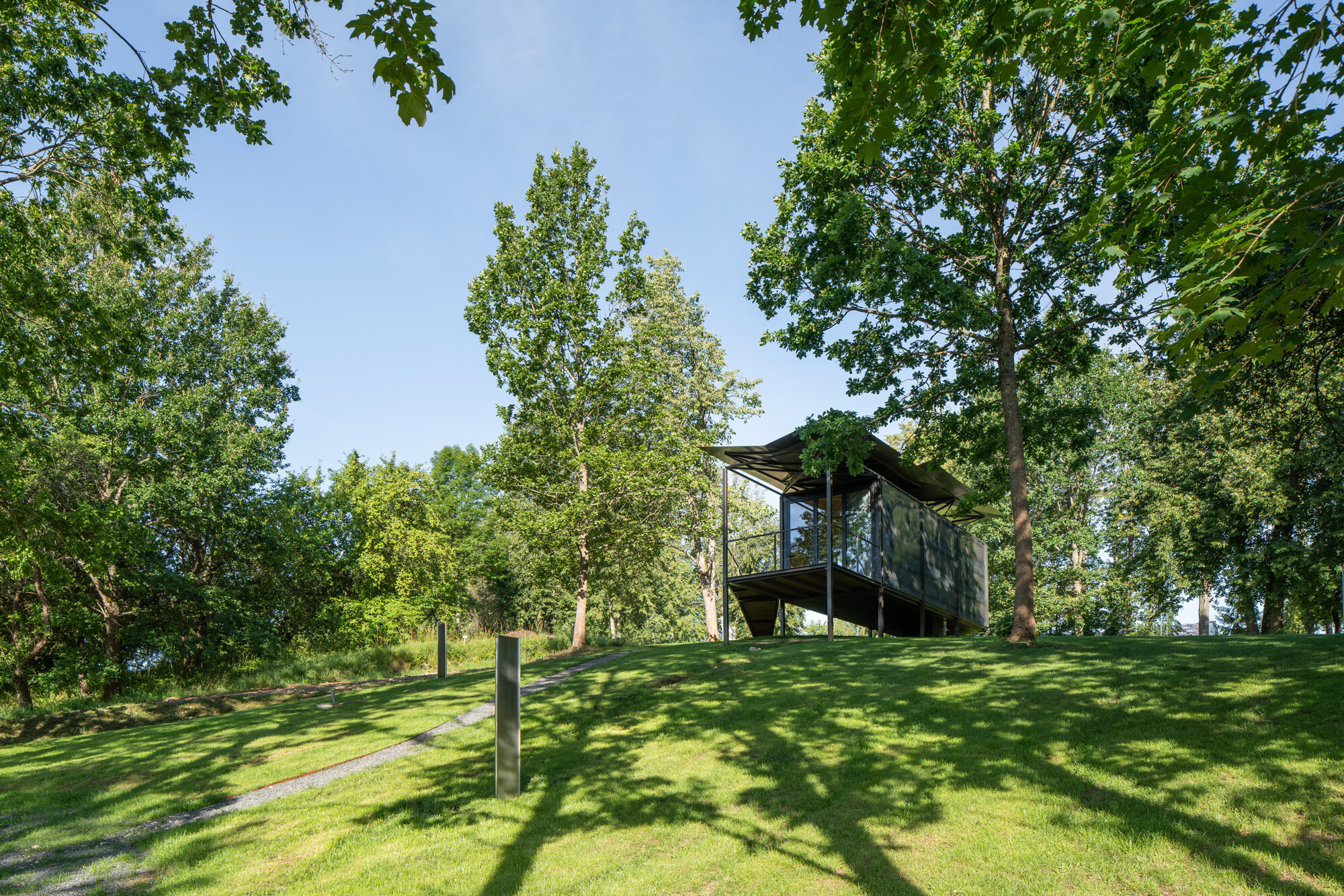 Ungefähr eine Stunde Fahrzeit nördlich von der Hauptstadt Vilnius erweitert bei Zalvariai der Prototyp einer modularen Stahlhütte auf Stelzen einen naturnahen Ferienpark.