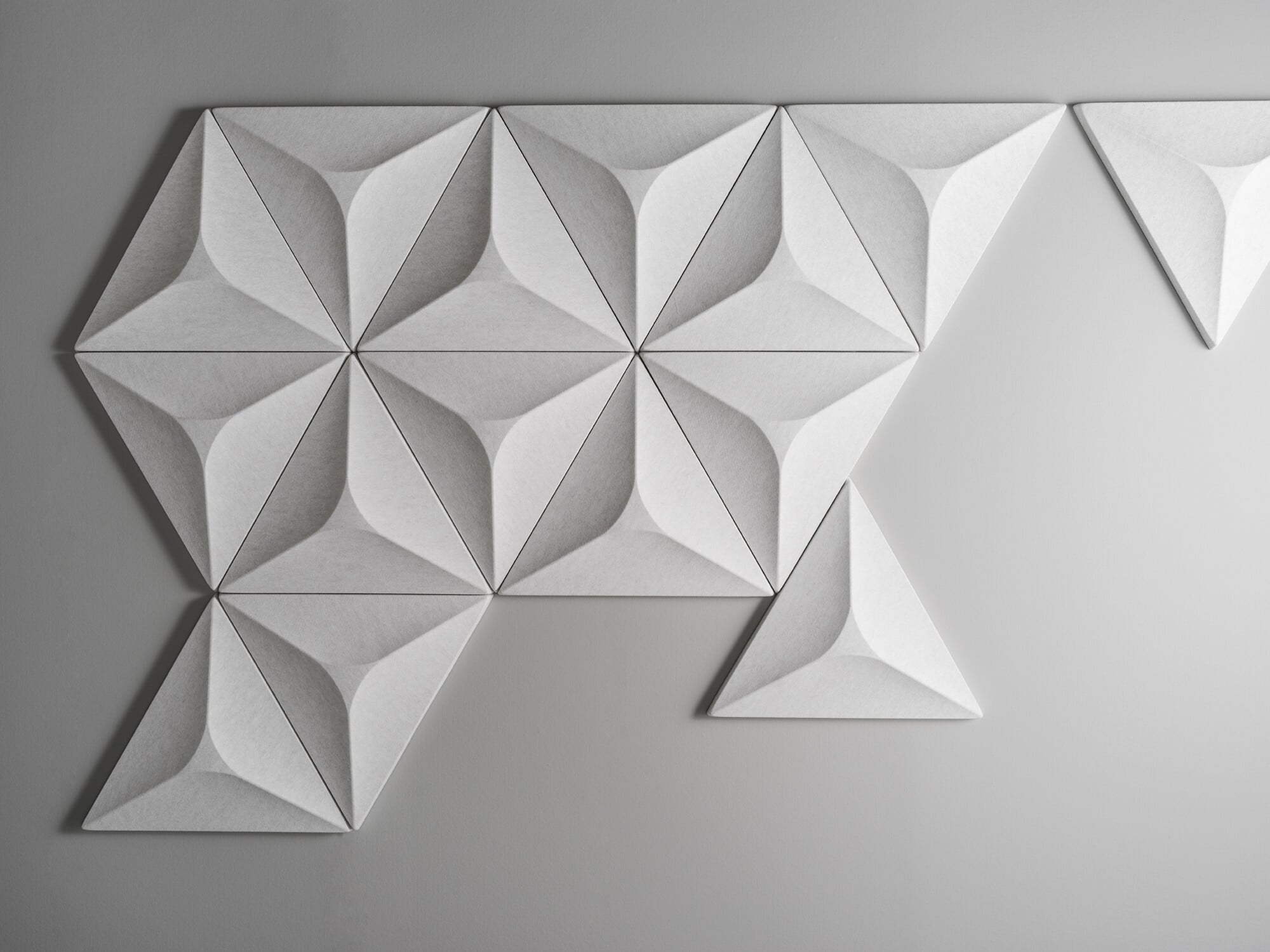 Der Entwurf für die spielerischen Akustikplatten mit dreieckiger Grundform stammt von der Designerin Layla Mehdi Pour, für die das Zusammenspiel von Ordnung und Unregelmäßigkeit wichtig war. 