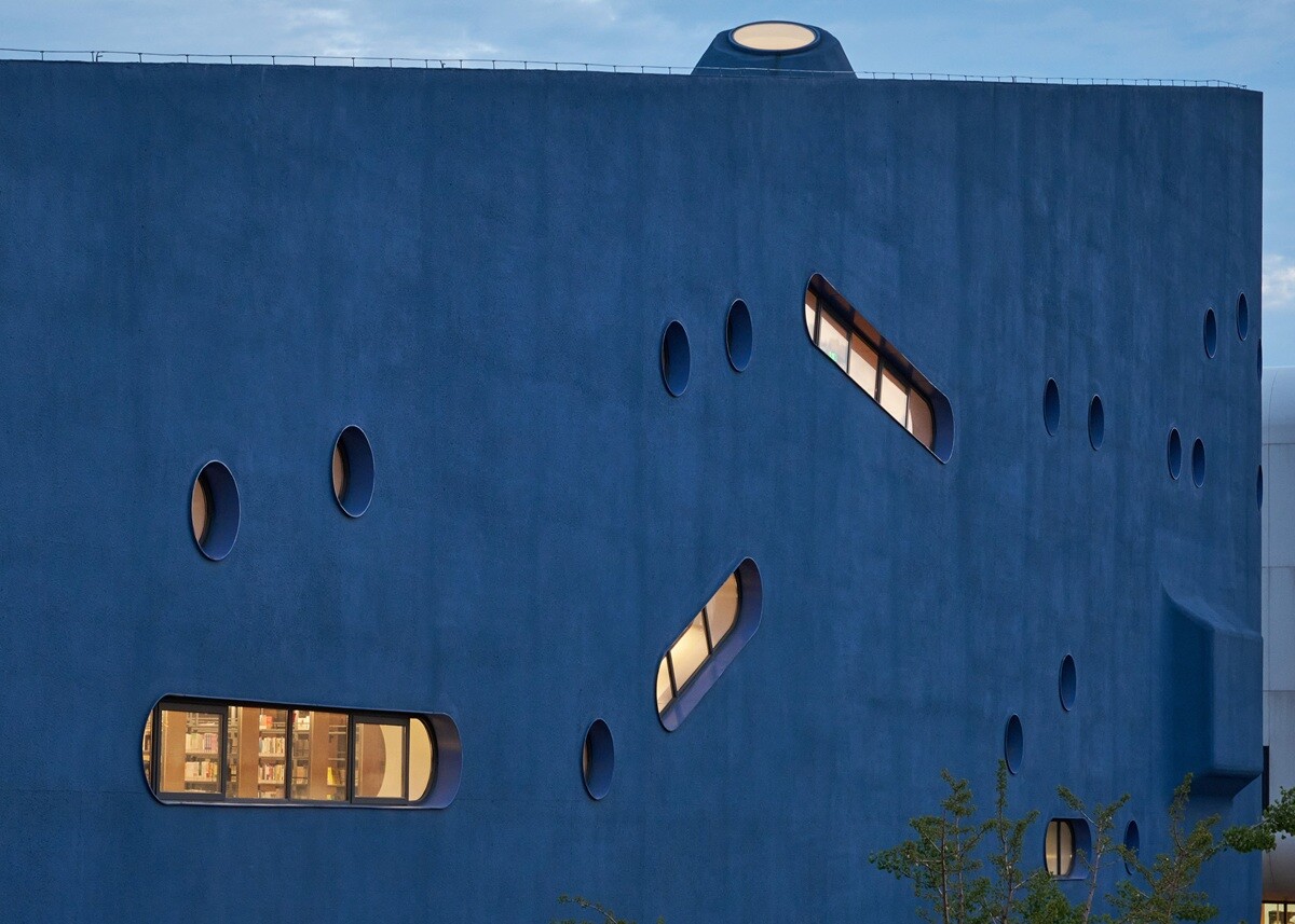 Mit seinen blauen Putzflächen ist das sogenannte Bibliotheater die Landmarke des Schulcampus.