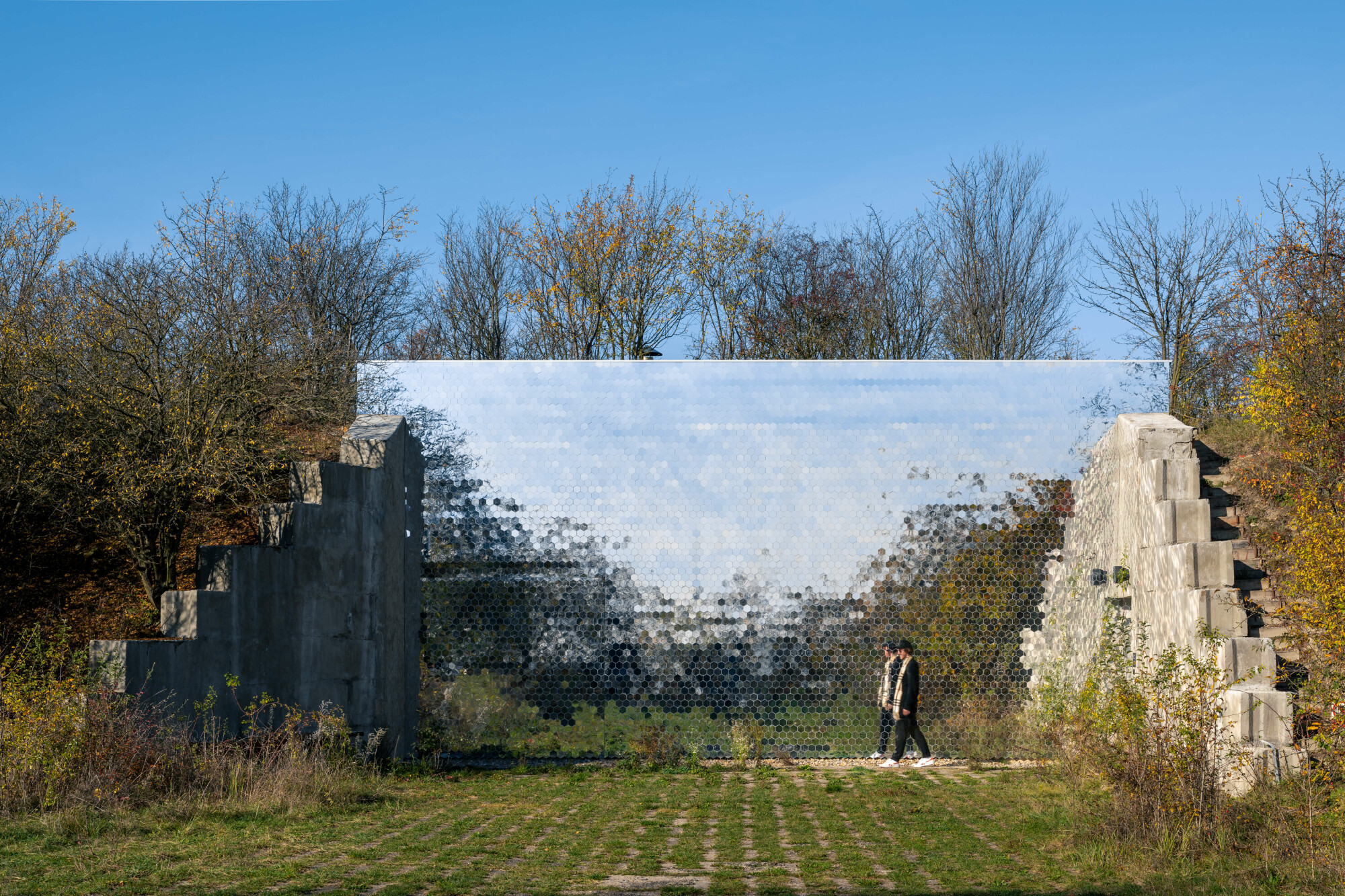 Die Architekturschaffenden haben eine sechs Meter hohe Spiegelfläche vor den Bunker gesetzt.