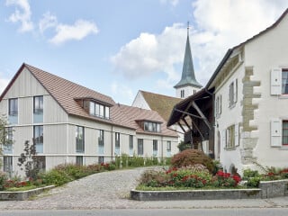 Buol & Zünd gestalteten ein Ensemble aus zwei Neubauten und zwei Umbauten, um den Dorfkern von Therwil für Senioren wieder attraktiv zum Wohnen zu machen.