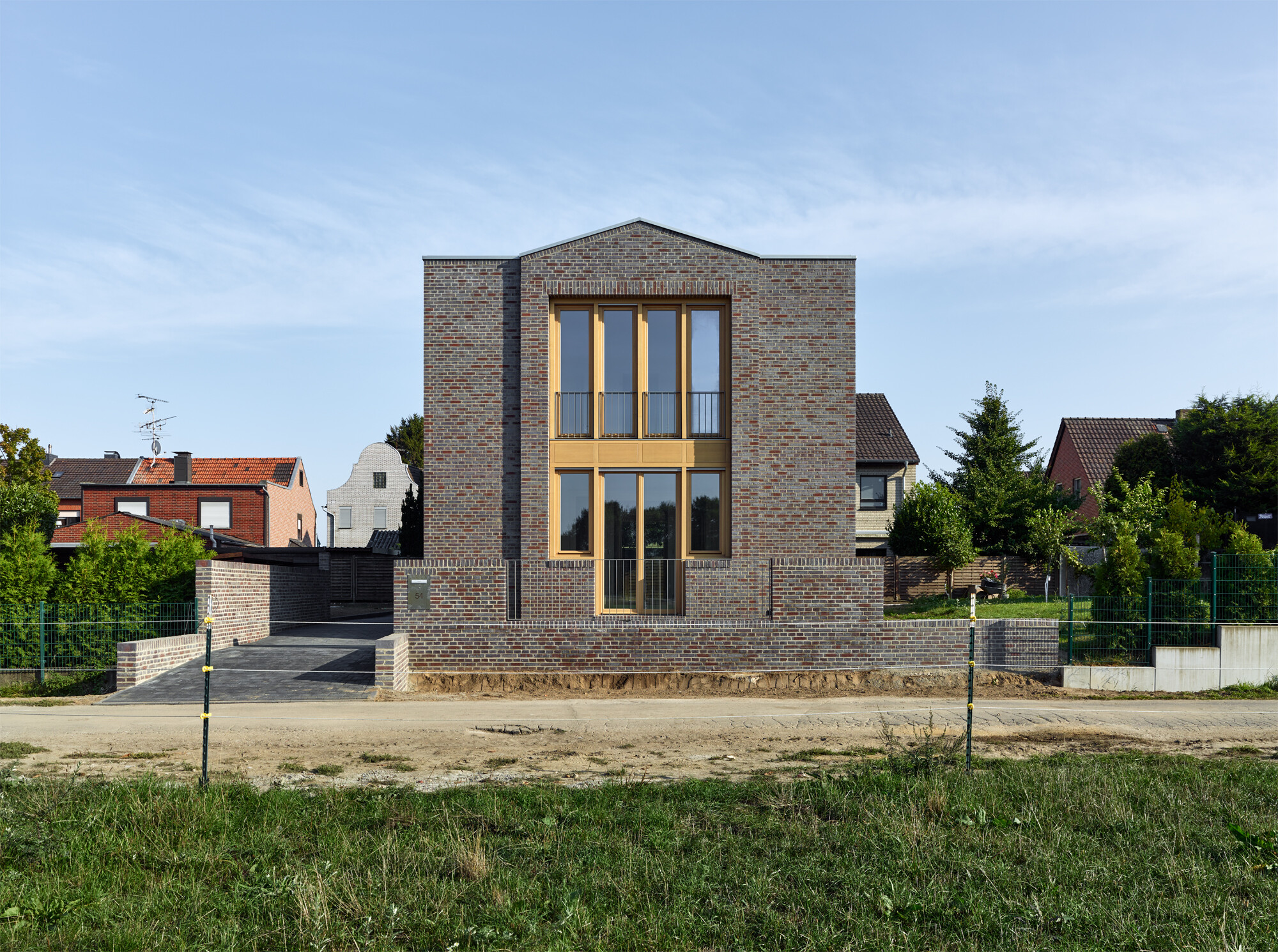 Das zweigeschossige Einfamilienhaus am Tackhütter Broich fügt sich zwar mit seiner schlichten Mauerwerksfassade in die umliegende Struktur ein, fällt aber durchaus durch seine Form auf.