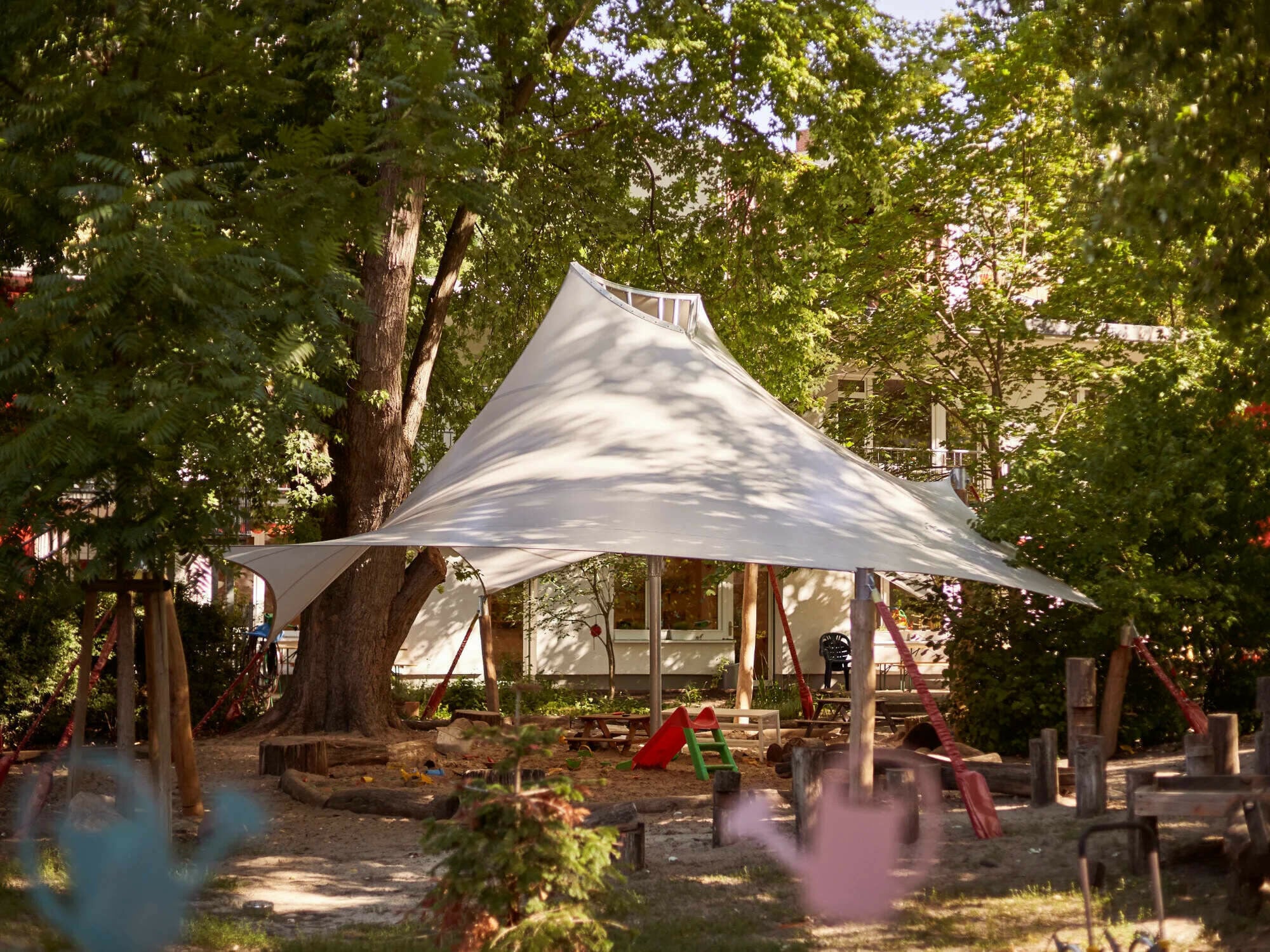 Eine Sandkastenüberdachung der besonderen Art haben die Planer von Stoffdach für den INA Kindergarten in Berlin realisiert.