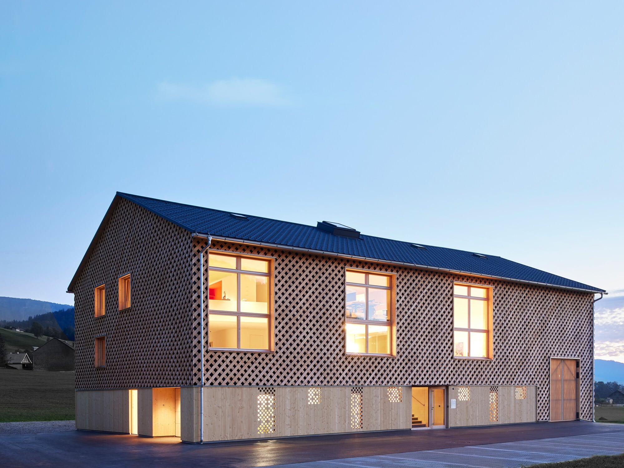 Die Fassade besteht aus einer wabenhaften Holzlattung, die eine dreidimensionale Wirkung erzeugt.