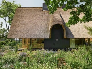 Das steile Pfettendach mit Reetdeckung ist das bestimmende architektonische Element von Haus B in Timmendorfer Strand.