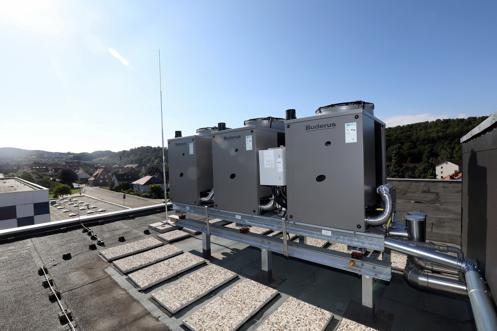 Eine Kaskade aus den drei Gas-Wärmepumpen Logatherm GWPL 41kW steht auf dem Flachdach des Schulgebäudes.