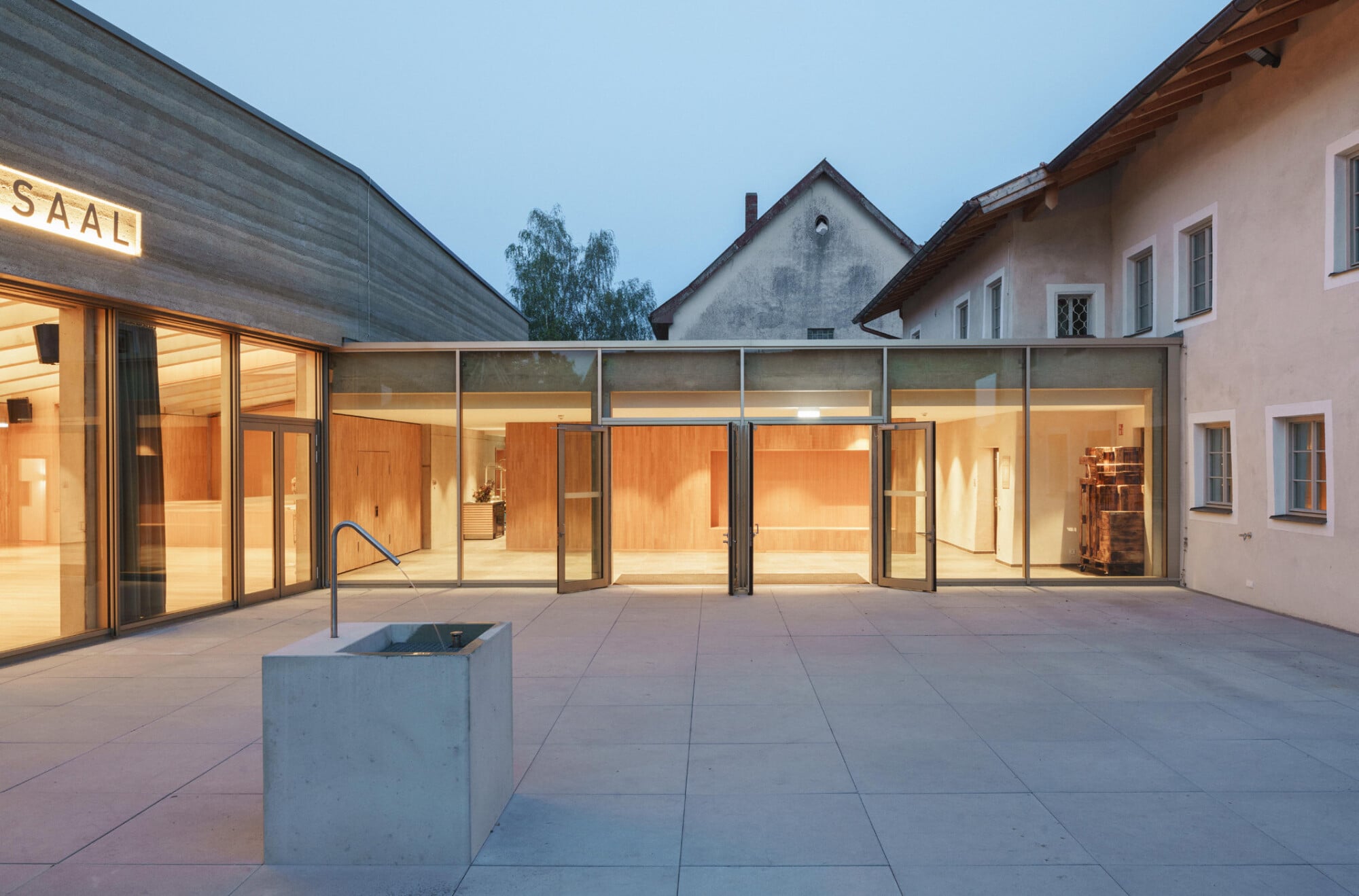 Das Foyer des Saals befindet sich in dem verbindenden Bauteil zwischen Gasthaus und Erweiterung und ist vollflächig verglast.