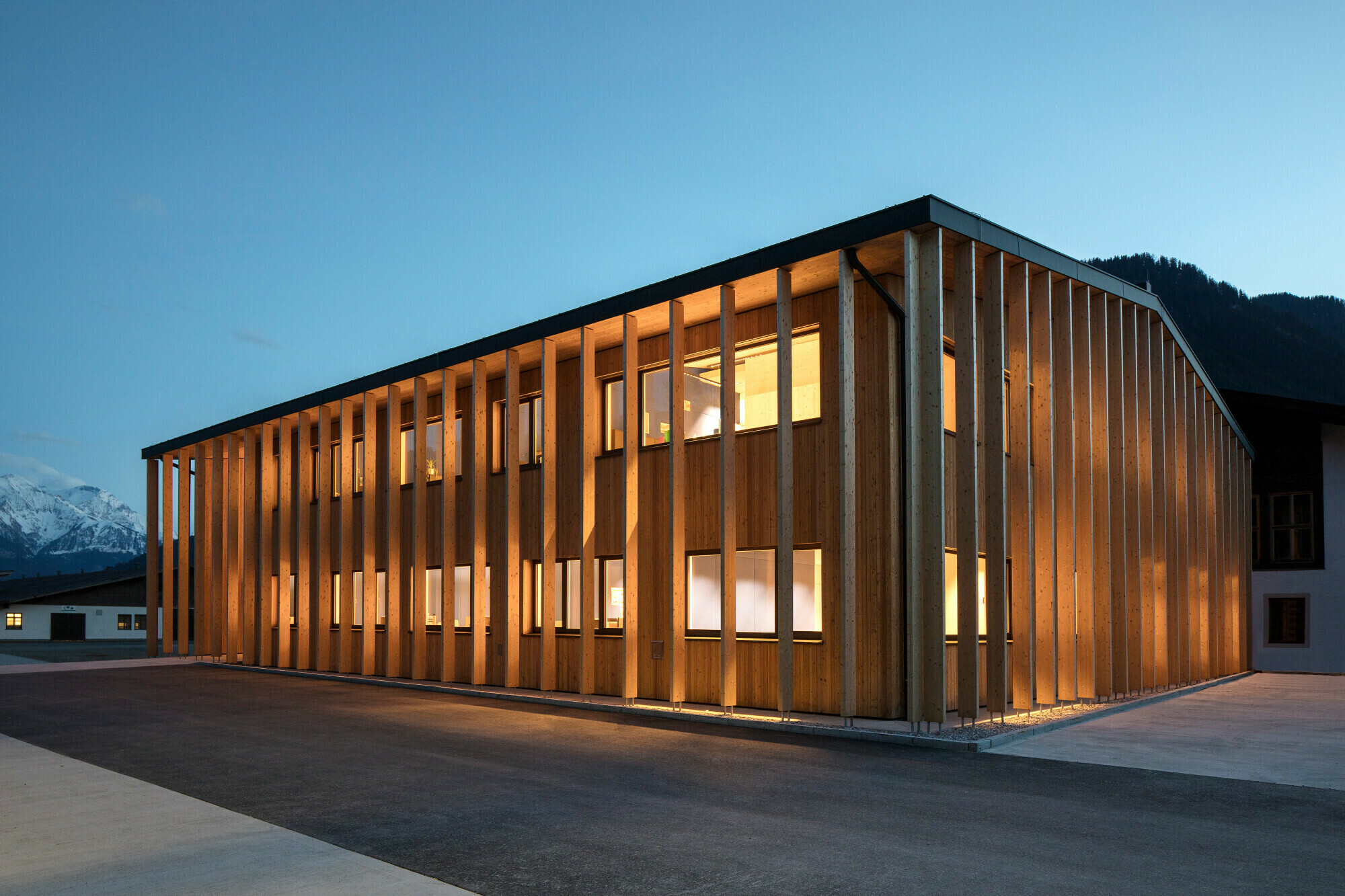 Die Fassade wird durch zweigeschossige nicht-tragende Holzelemente gegliedert.