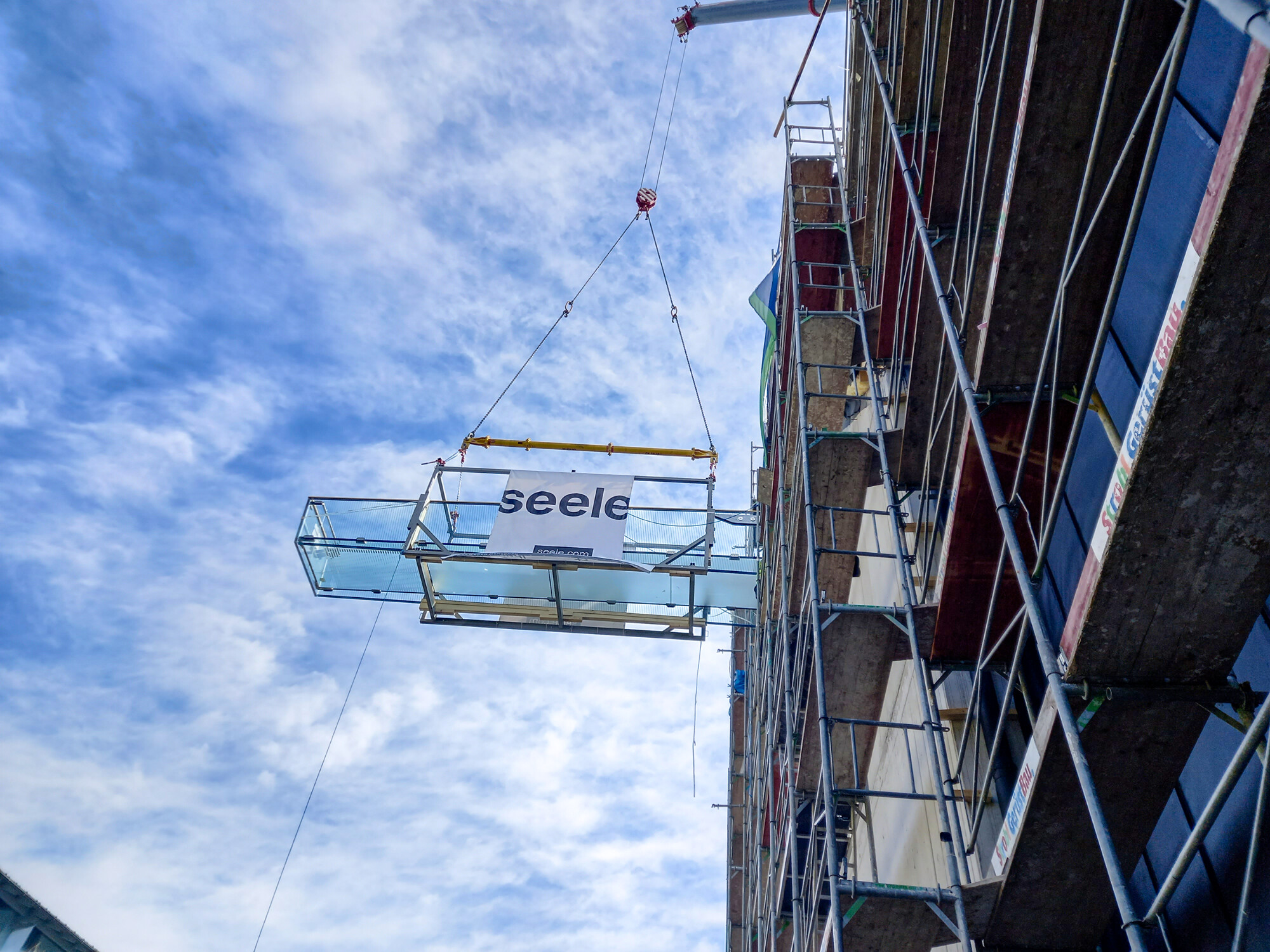 Der Glassteg wurde beim Hersteller vormontiert und mithilfe eines 45m langen Auslegers im Ganzen zur Einbaustelle im vierten Obergeschoß gehoben. 