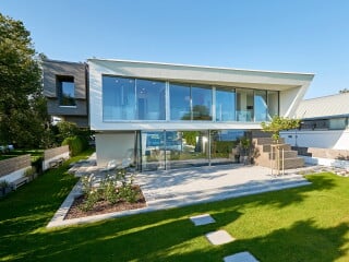 Atelier H2A entwarf ein zweigeschossiges Einfamilienhaus, das über großflächige Verglasungen stets einen Bezug zum Bodensee sucht.