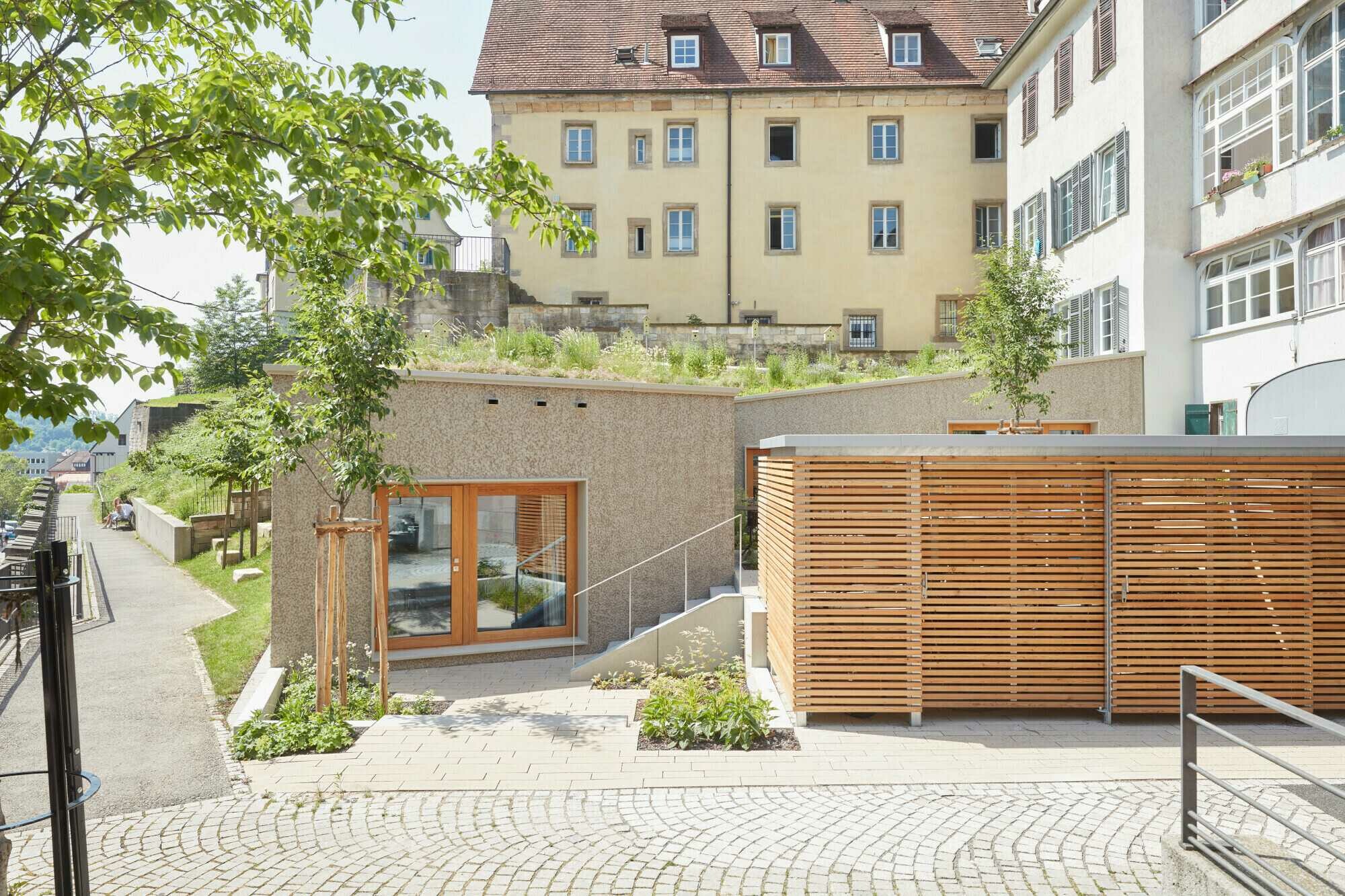 Das Projekt umfasst den Umbau des Erdgeschosses des Altbaus sowie einen eingeschossigen Erweiterungsbau, der sich über einen Teil der Schulbergterrassen winkelförmig erstreckt.