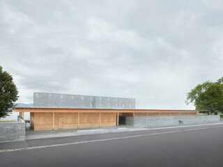 Begrenzungsmauern in hellem Sichtbeton schotten das Strandbad von der stark befahrenen Straße ab.