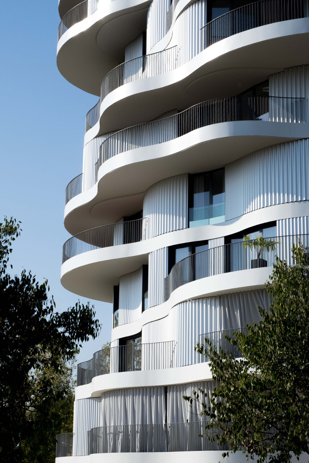 Das Bauwerk zeichnet sich durch eine verspielte, von Wellenformen geprägte Fassade aus. 
