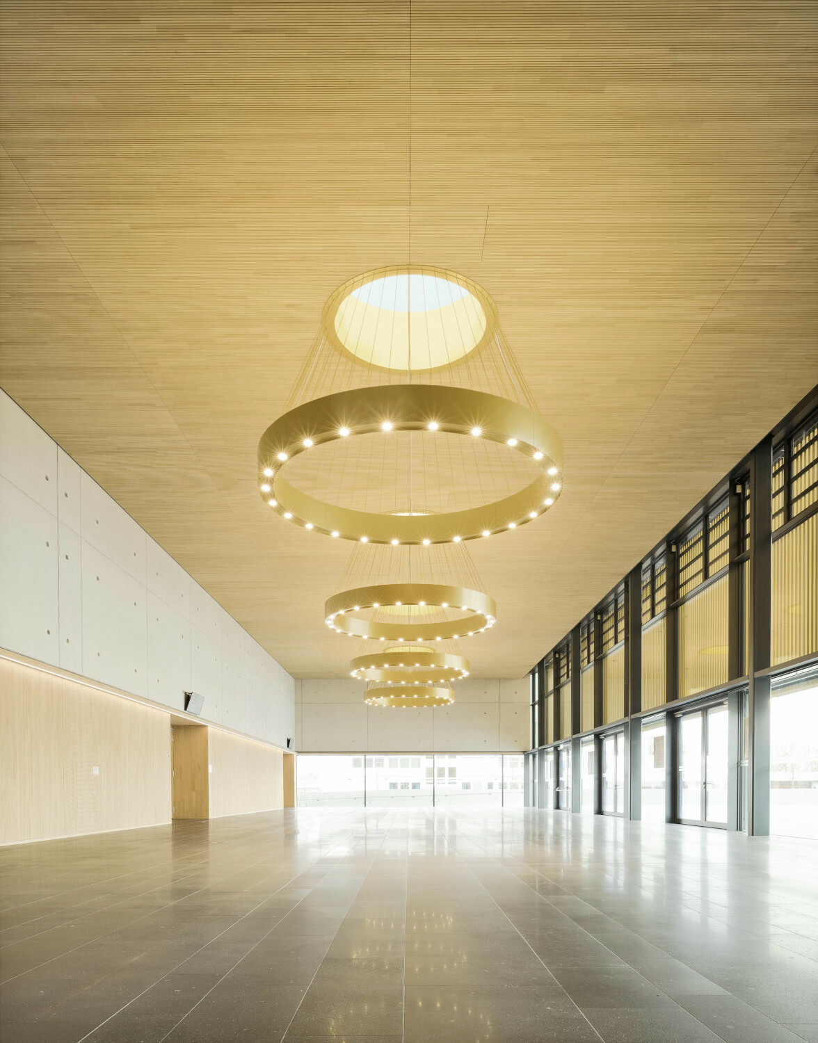 Die vertikal gegliederte metallische Fassade korrespondiert mit der Farbe und Struktur der Holzbekleidung in Foyer und Restaurant, den Tagungsbereichen und dem rund 680 Quadratmeter großen Saal. 