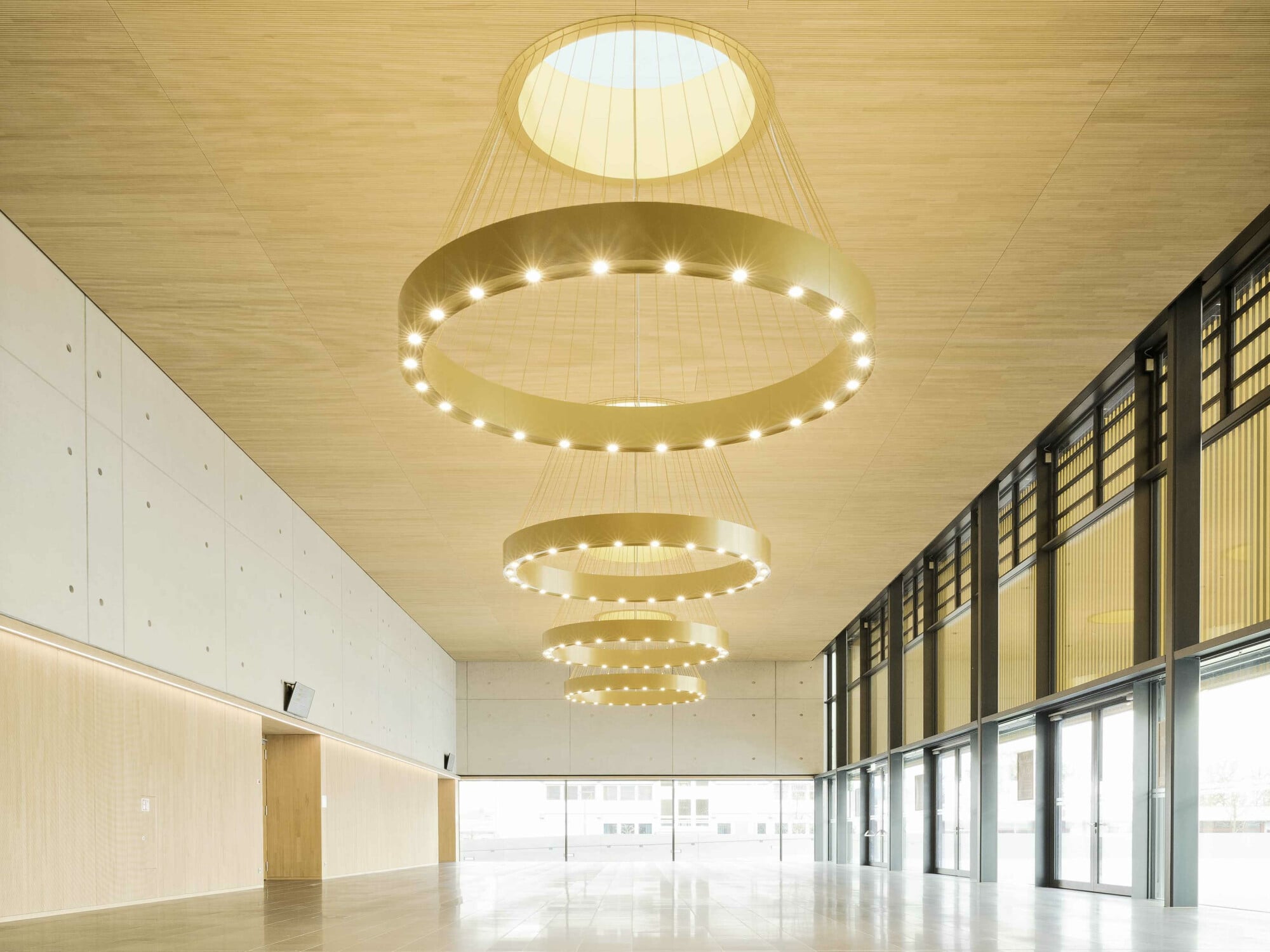 Das dreigliedrige Gebäudevolumen nach Plänen von Lamott.Lamott Architekten zeigt sich einladend und repräsentativ, arrangiert um einen erhöhten öffentlichen Platz. 