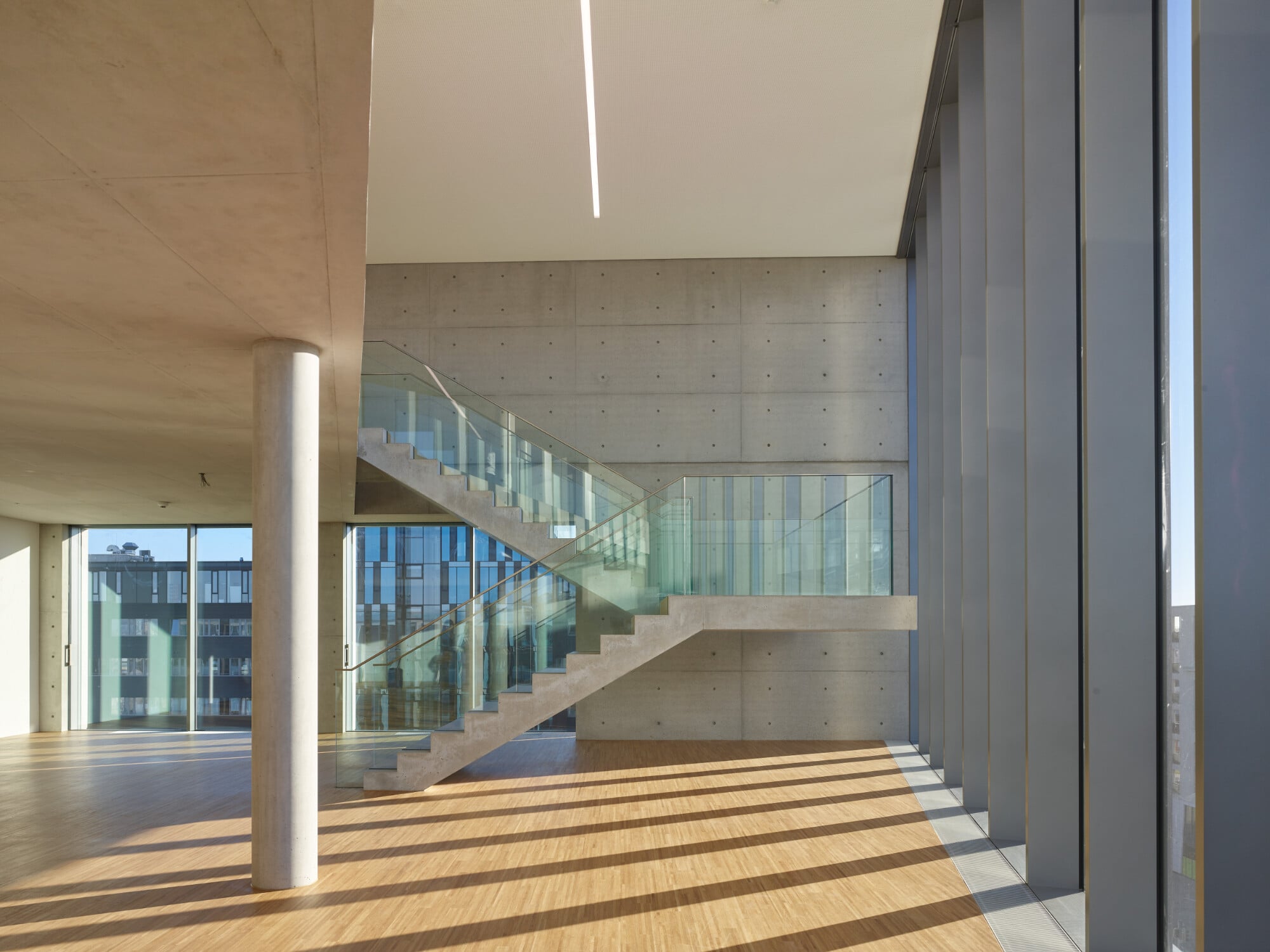In der sogenannten Skylounge in der Südwestecke führt eine freitragende Sichtbetontreppe auf eine Galerie, die zur Dachterrasse überleitet.