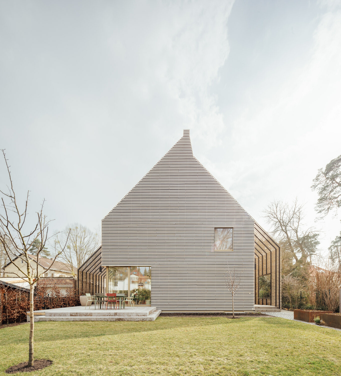 Neben der hellen Holzbekleidung sind die Pergolen an beiden Seiten ein besonderes Merkmal des Hauses, welches rundzwei Architekten geplant haben.