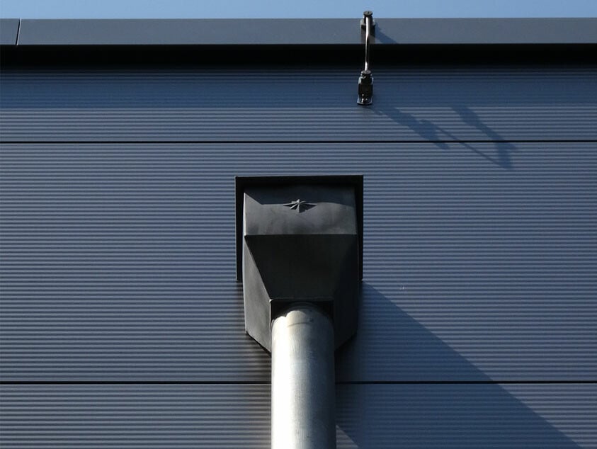 Attikaentwässerung mit Fallrohr an einer Sporthalle