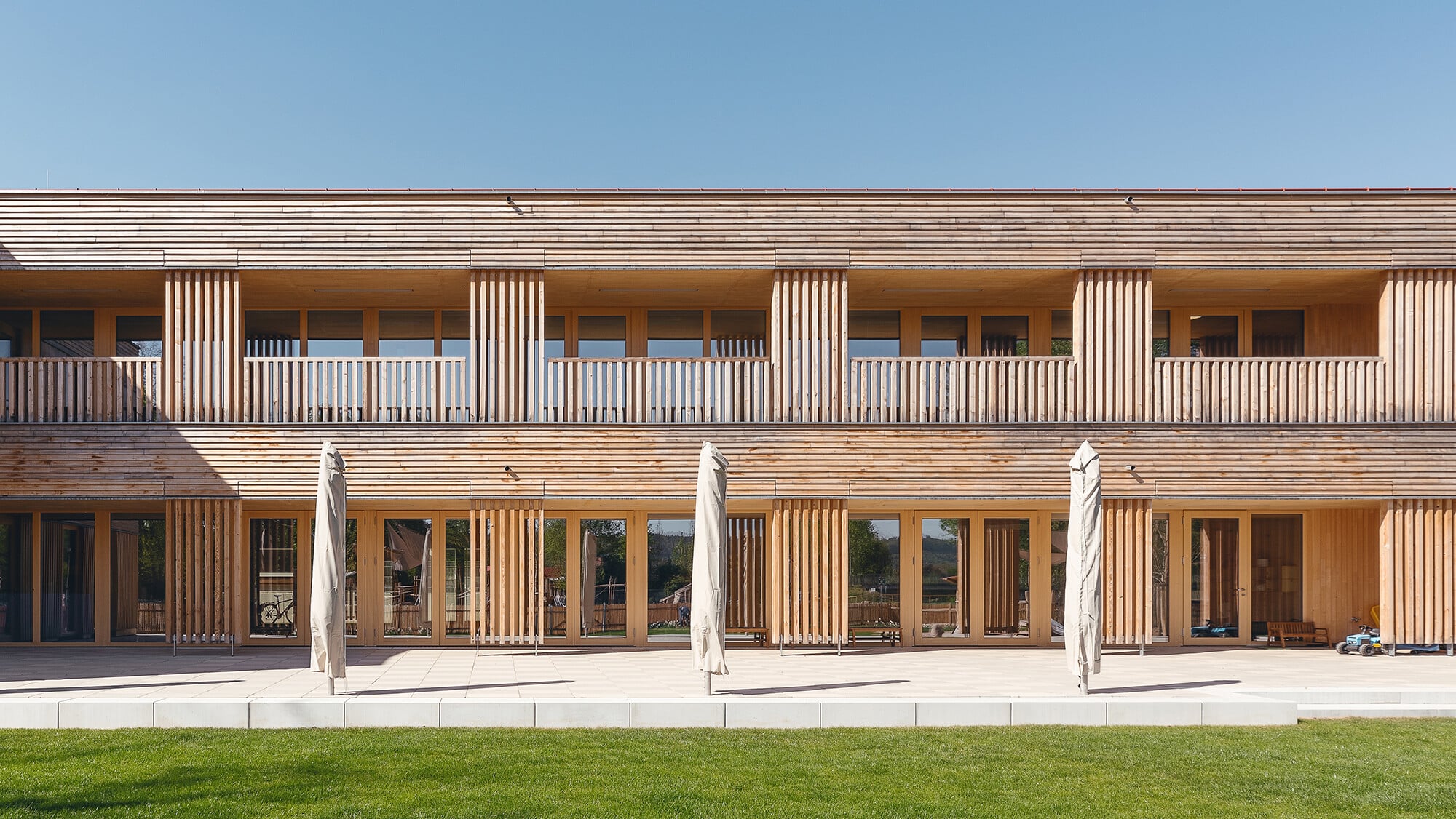 Ansicht Süd: Horizontal und vertikal angeordnete Leisten und Verschalungen aus unbehandeltem Weißtannenholz gliedern die Fassade.