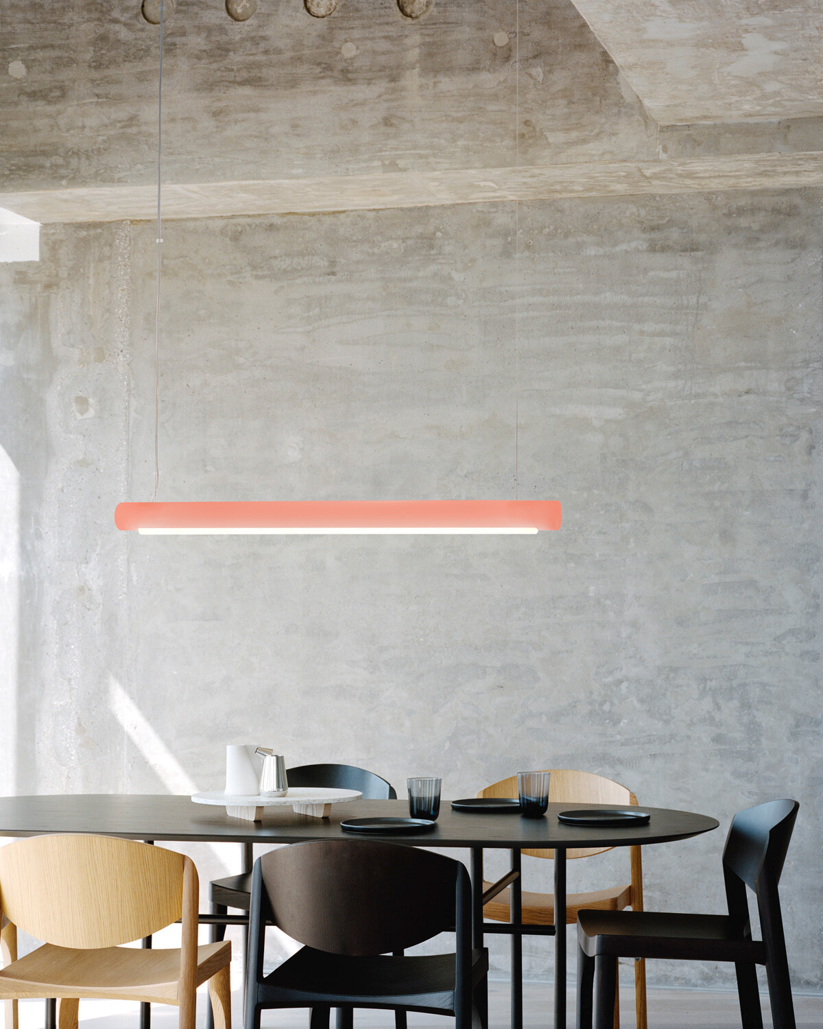Die geradlinige, sehr technische Form eines Zylinders erinnert an eine typische Arbeitsleuchte, während das Material eine behagliche Lichtstimmung erzeugt.