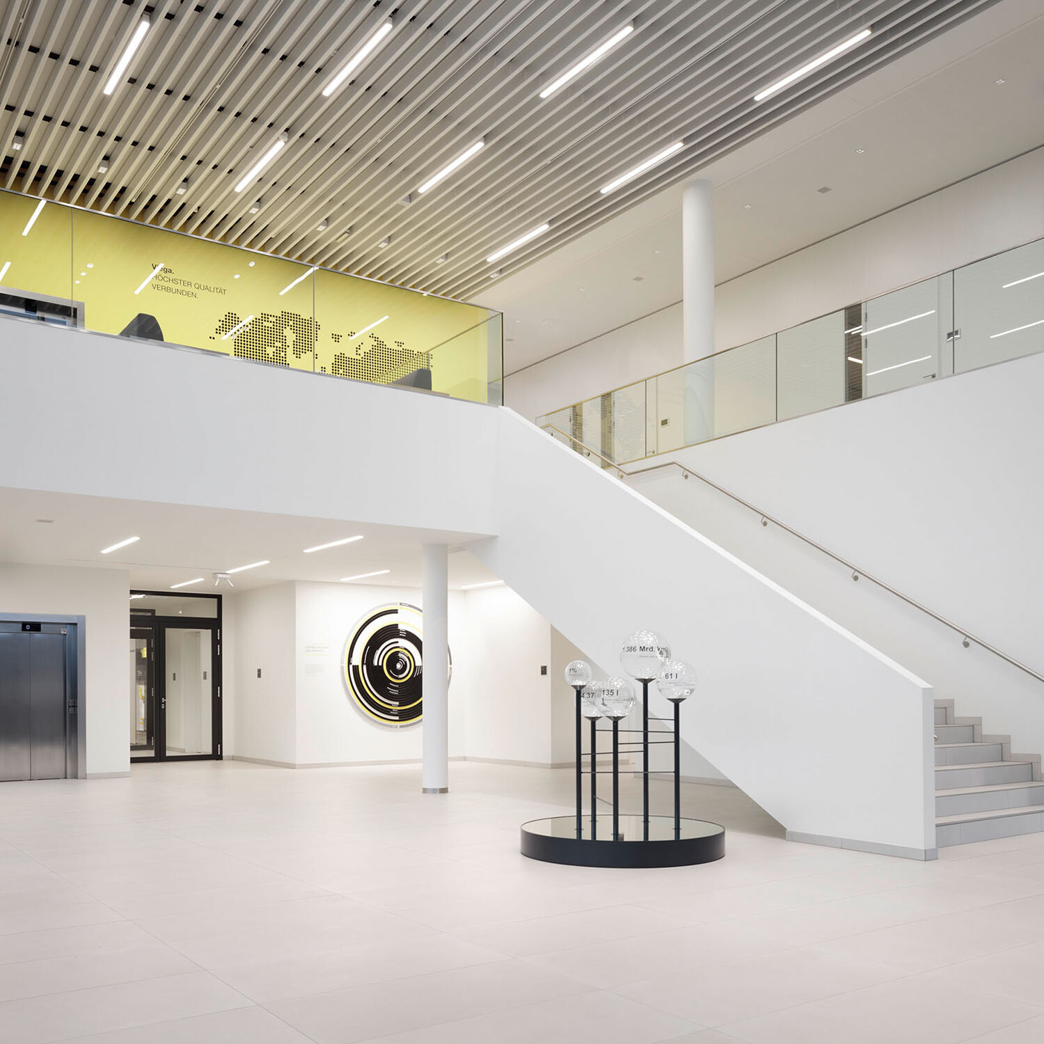 Eine raumgreifende Treppe erschließt das anschließende Galeriegeschoss sowie weitere Funktionsbereiche in den Obergeschossen.