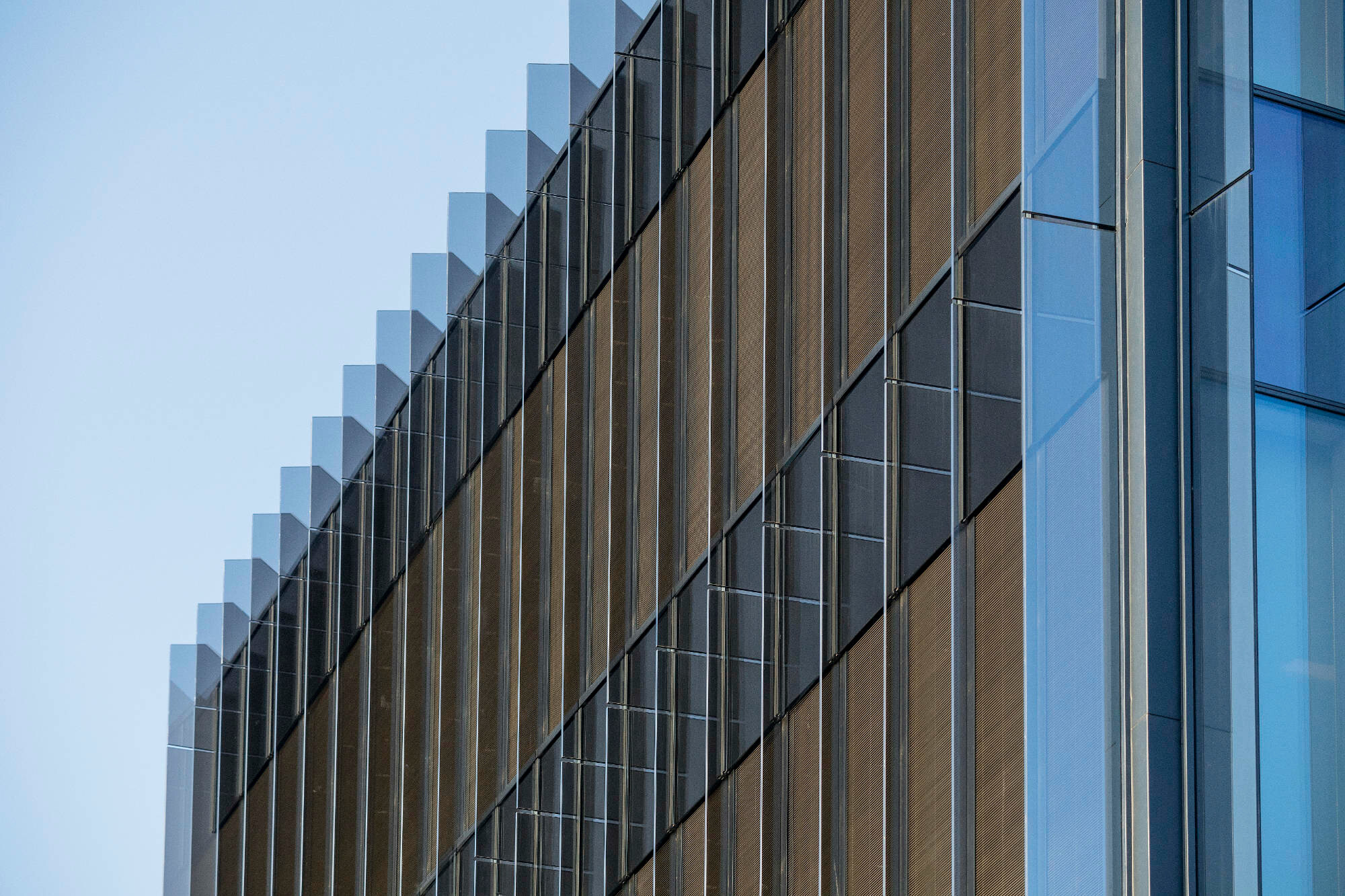 Gläserne Vertikallamellen an der Fassade dienen als Sonnenschutz.